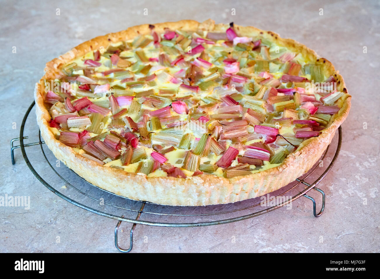 Torta al rabarbaro a destra fuori del forno raffreddare su una griglia di metallo Foto Stock