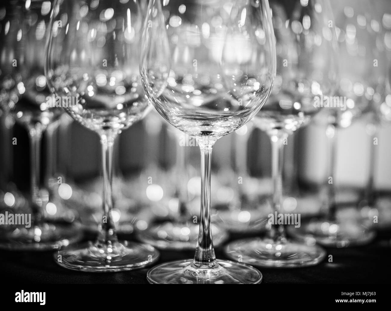 Riga vuota di bicchieri di vino sul tavolo | Bianco e nero | Close up Foto Stock