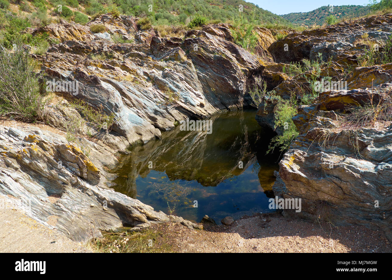 L'acqua stagnante isolato in pietra bagno costituito dal flusso d'acqua. Pulo do Lobo, Guadiana River Valley Natural Park, Alentejo, Portogallo. Foto Stock
