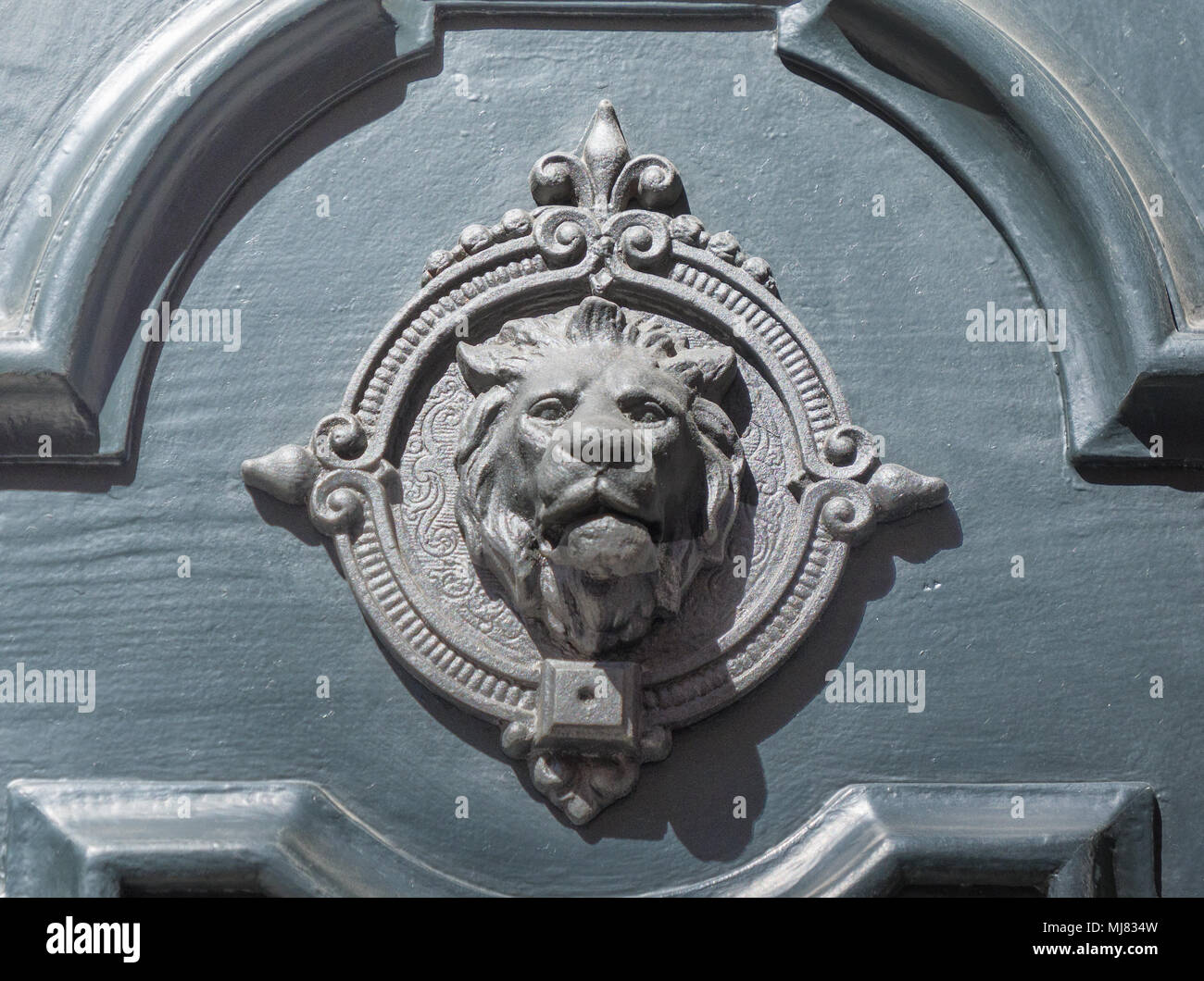 Antico portale in legno decorativa con un leone la faccia Foto Stock