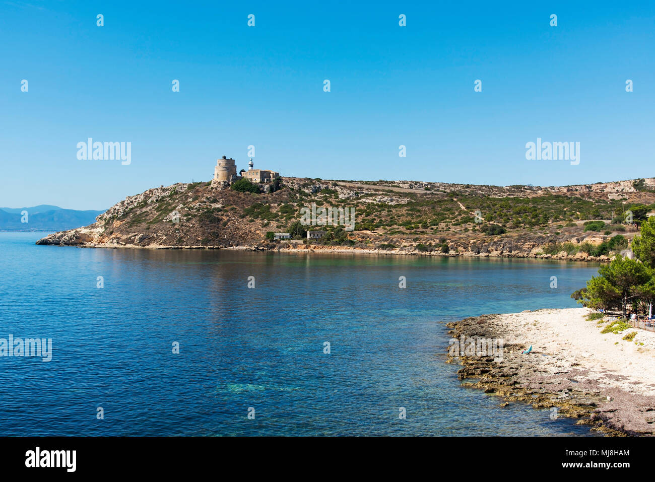 Una vista della costa di Calamosca a Cagliari, Sardegna, evidenziando il Calamosca tower e il faro di Capo Sant'Elia sulla sinistra Foto Stock