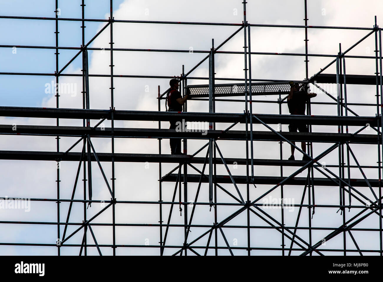 Ponteggio builder durante lo smantellamento di un grande, free-standing impalcature, Foto Stock