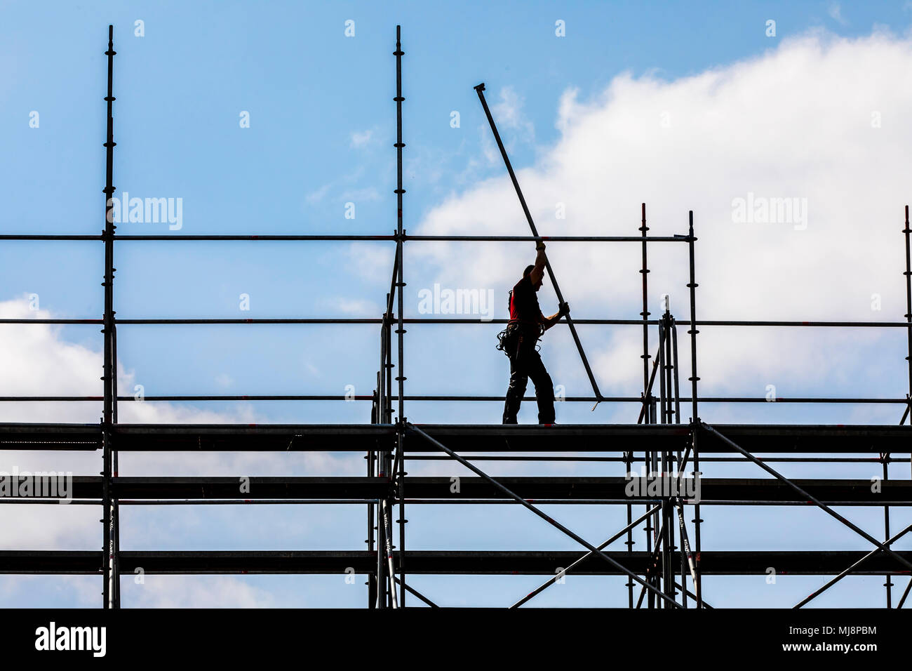 Ponteggio builder durante lo smantellamento di un grande, free-standing impalcature, Foto Stock