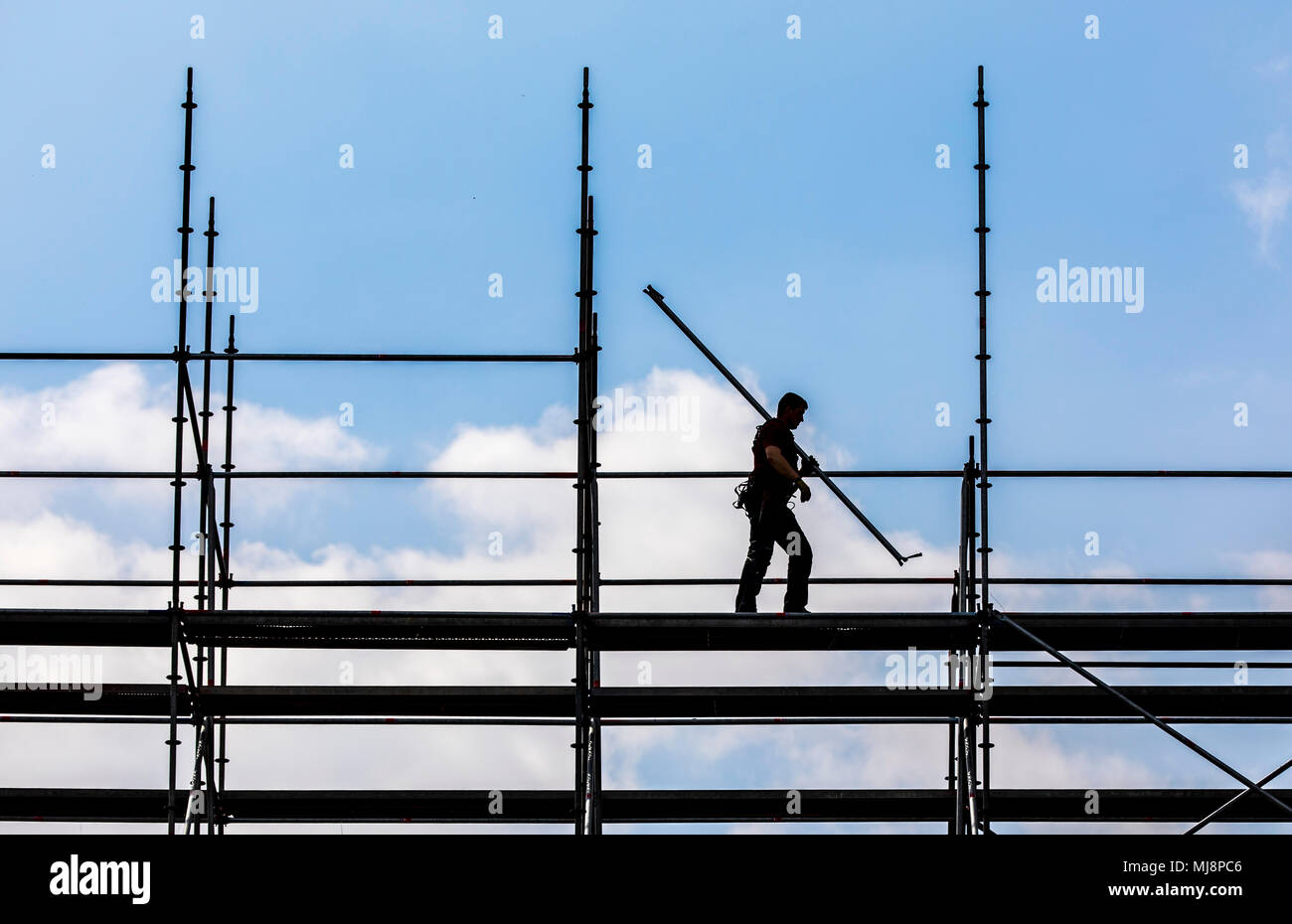 Ponteggio builder durante lo smantellamento di un grande, free-standing impalcature, Foto Stock
