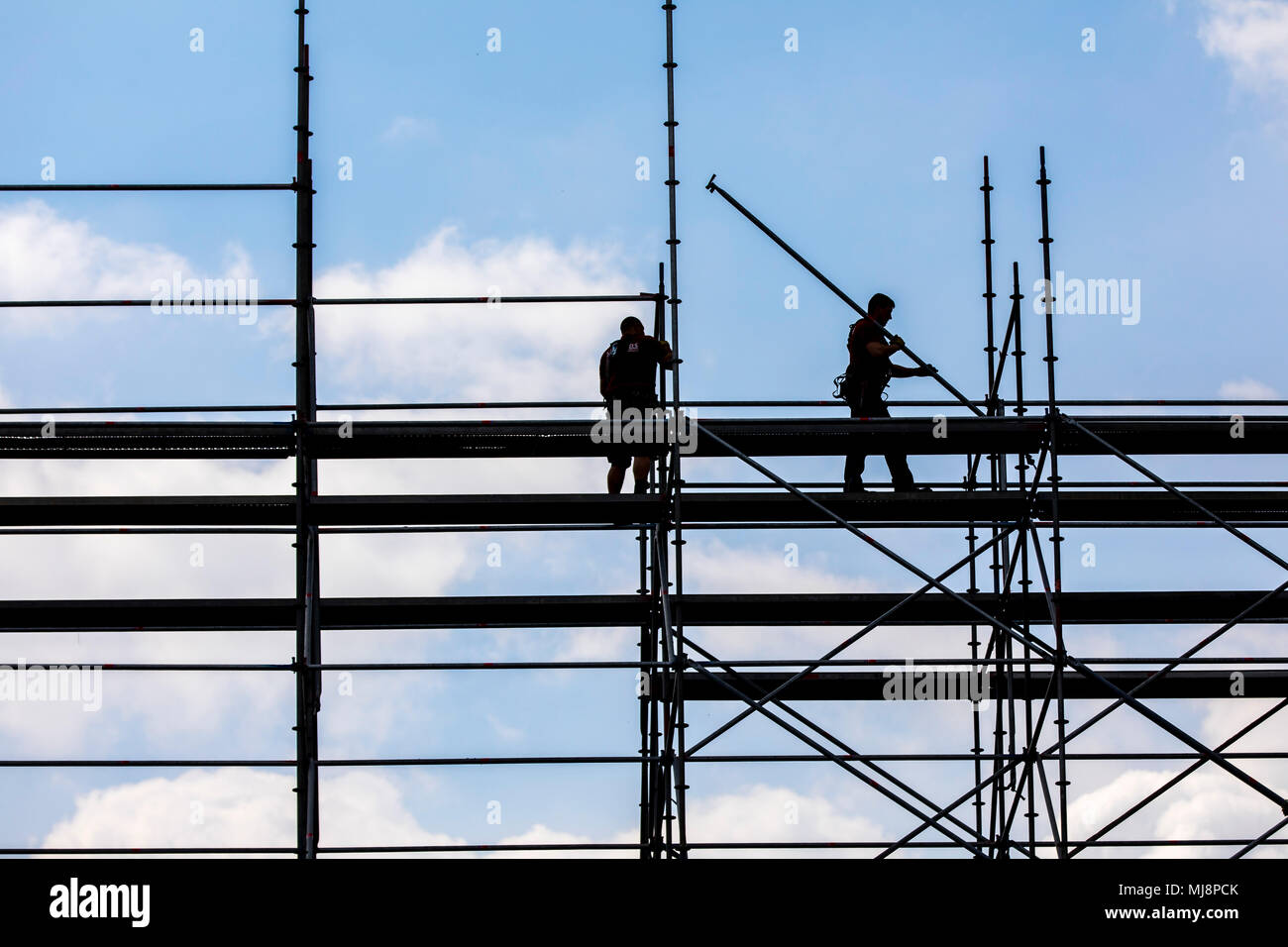 Ponteggio builder durante lo smantellamento di un grande, free-standing impalcature, Foto Stock