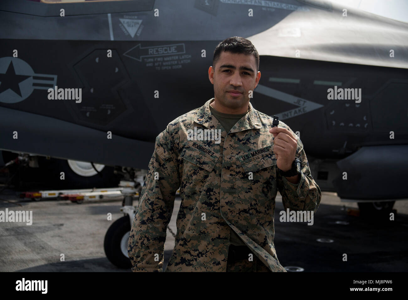 Chief Warrant Officer 2 Daniel Rodriguez, un responsabile di manutenzione con il combattimento il battaglione della logistica 31, 31 Marine Expeditionary Unit, detiene un 3-D stampato paraurti in plastica per una F-35B Lightning II landing gear porta a bordo della USS Wasp (LHD-1) mentre è in corso nell'Oceano Pacifico, 19 aprile 2018. Marines con CLB-31 sono ora in grado di 'produzione additiva", noto anche come stampa 3-D, che è la tecnica di replica di digital 3-D i modelli come oggetti tangibili. Il trentunesimo Marine Expeditionary Unit partner con la marina militare del squadrone anfibio 11 per formare la Vespa Anfibia Gruppo pronto, un coesivo b Foto Stock