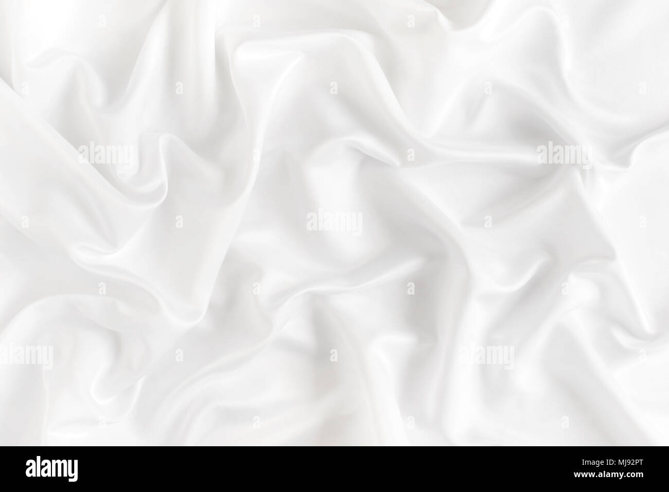 Close up di increspature su bianco tessuto di seta. In raso sfondo tessili. Foto Stock