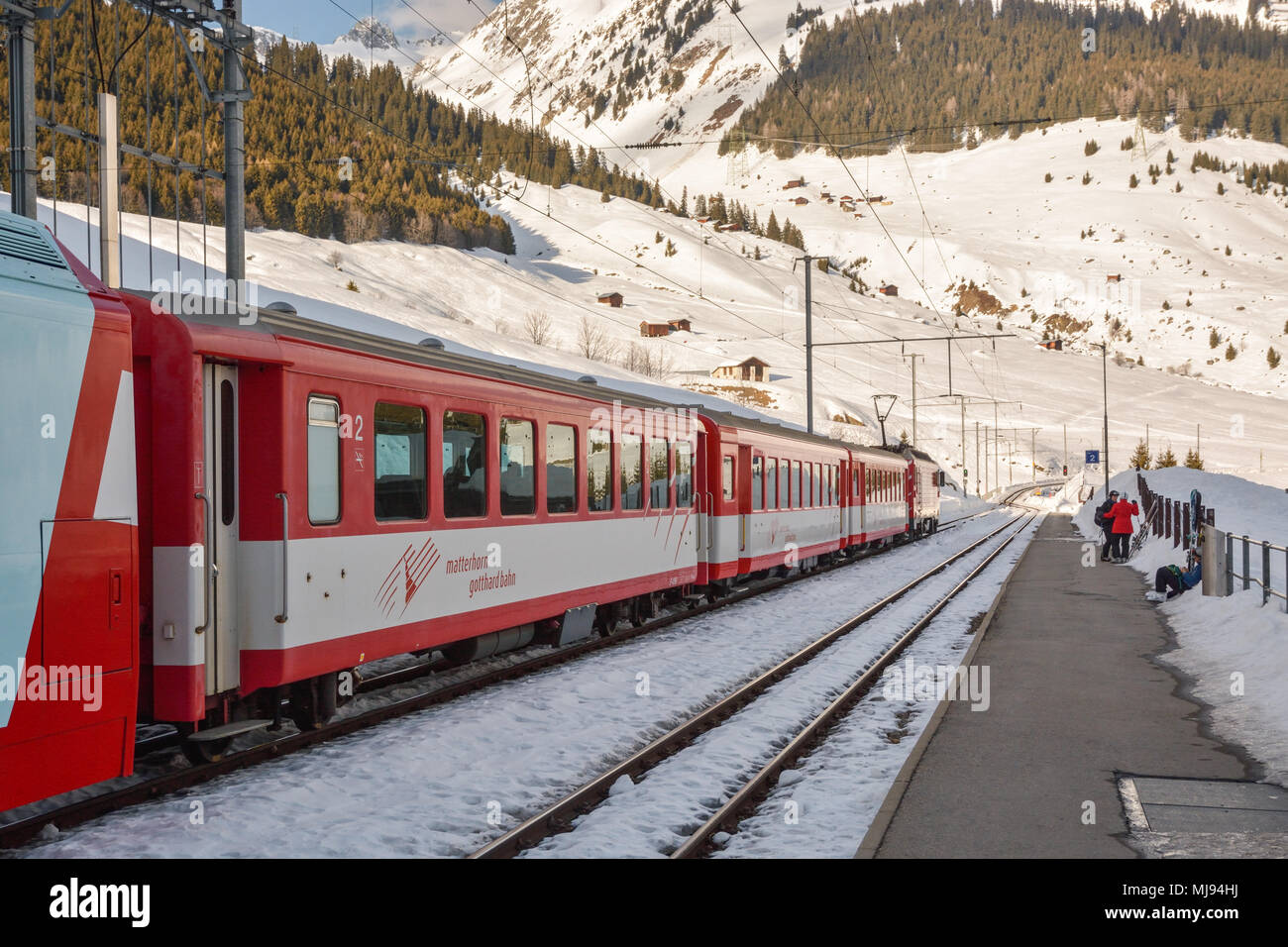 DIENI, Svizzera - 9 febbraio 2018: gli sciatori in attesa del loro treno su Dieni stazione ferroviaria in Svizzera. Il treno li porterà via dell'Oberalp moun Foto Stock