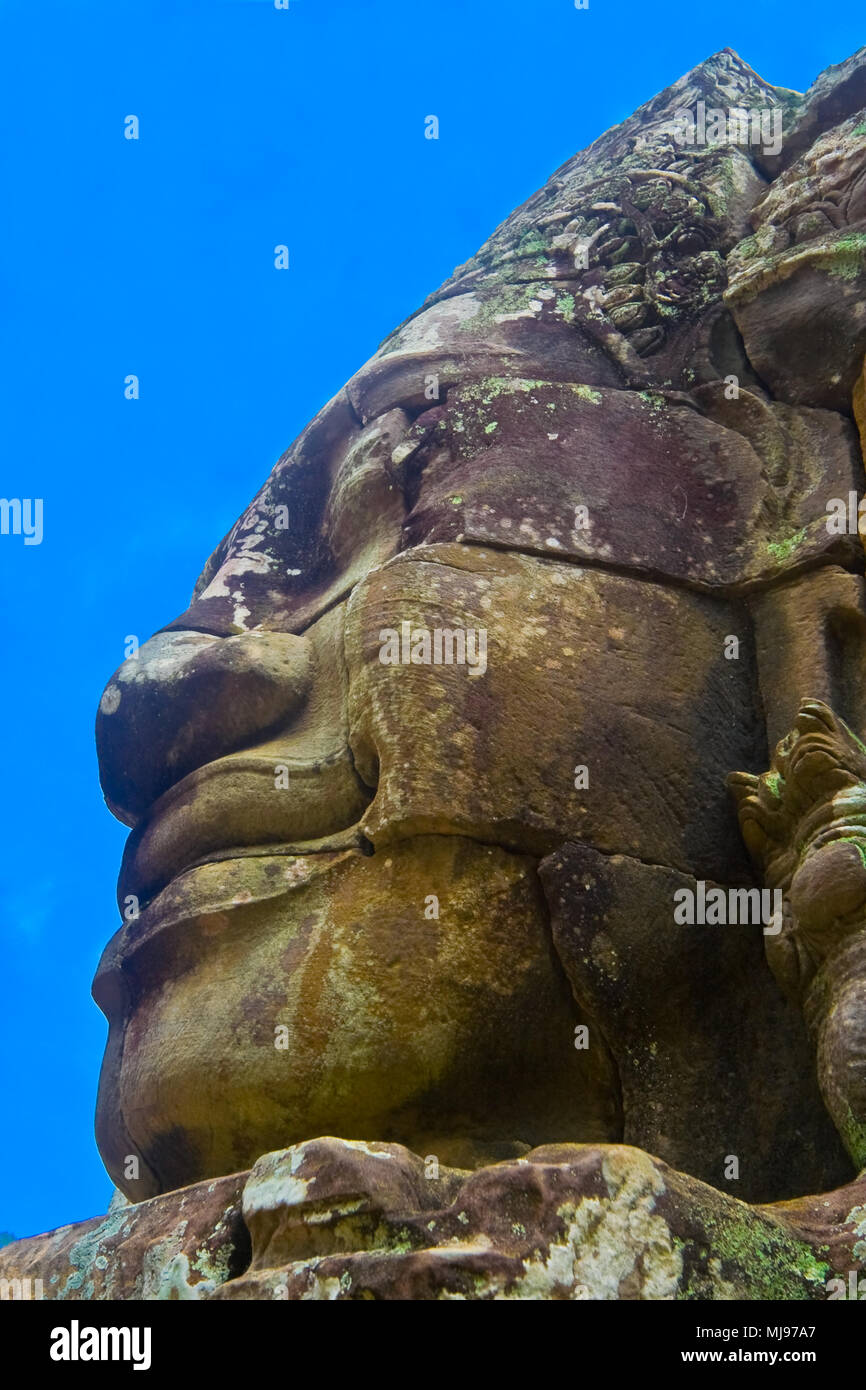 Profilo laterale di una monumentale faccia di pietra con un sereno e sorridente espressione su un cielo blu sullo sfondo. Foto Stock