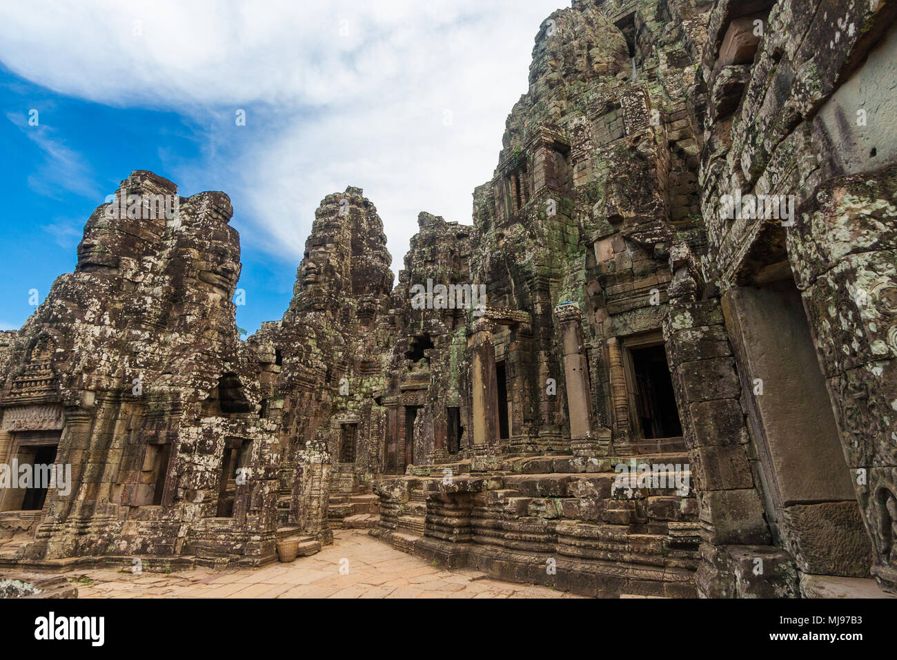 Ottima vista del terzo livello di involucro della Cambogia il famoso tempio Bayon sotto un cielo blu. Sulla destra si erge il Santuario centrale del tempio. Foto Stock