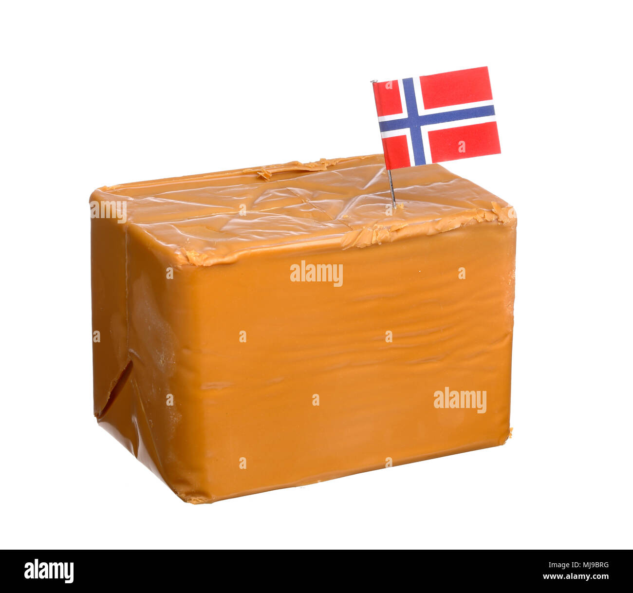 Un blocco norvegese di formaggi di siero di latte effettuate con crema di mucca e latte di capra con una bandiera norvegese, isolato su sfondo bianco. Foto Stock