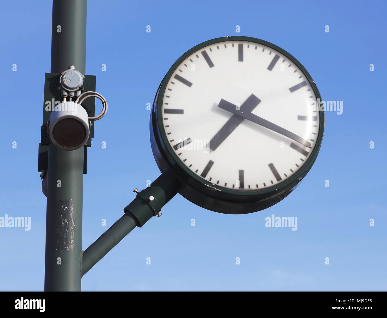 Un orologio pubblico senza cifre con altoparlanti montati su un palo a una svedese railroad station isolato sul cielo blu.. Foto Stock