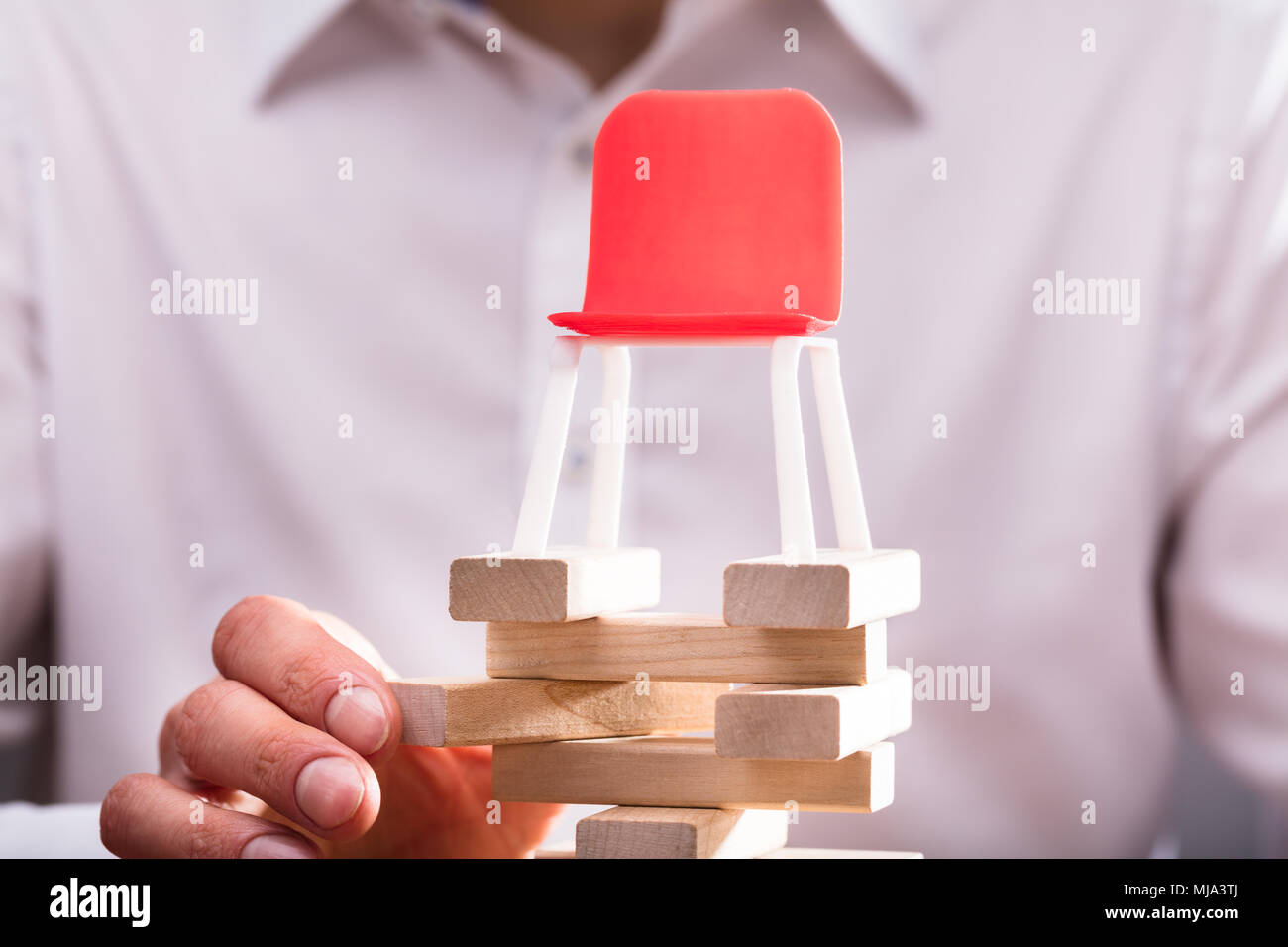 Close-up di una sedia rossa sulla mano umana disporre dei blocchi di legno Foto Stock