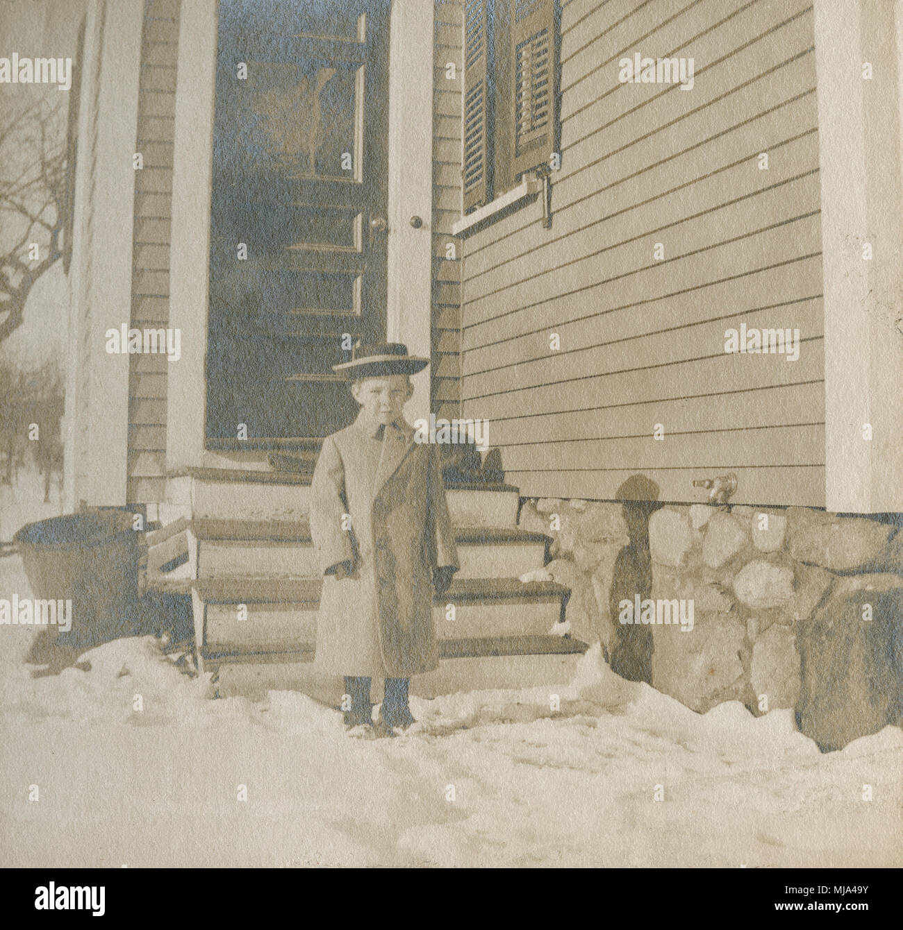 Antique c1905 la fotografia del giovane ragazzo in capi di abbigliamento in stile Vittoriano al di fuori in inverno. Posizione sconosciuta, probabilmente la Nuova Inghilterra, Stati Uniti d'America. Fonte: originale stampa fotografica. Foto Stock