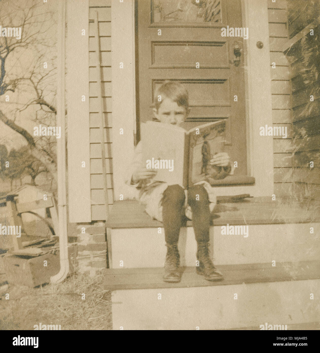 Antique c1905 la fotografia del giovane ragazzo lettura libro vittoriano su scale. Posizione sconosciuta, probabilmente la Nuova Inghilterra, Stati Uniti d'America. Fonte: originale stampa fotografica. Foto Stock
