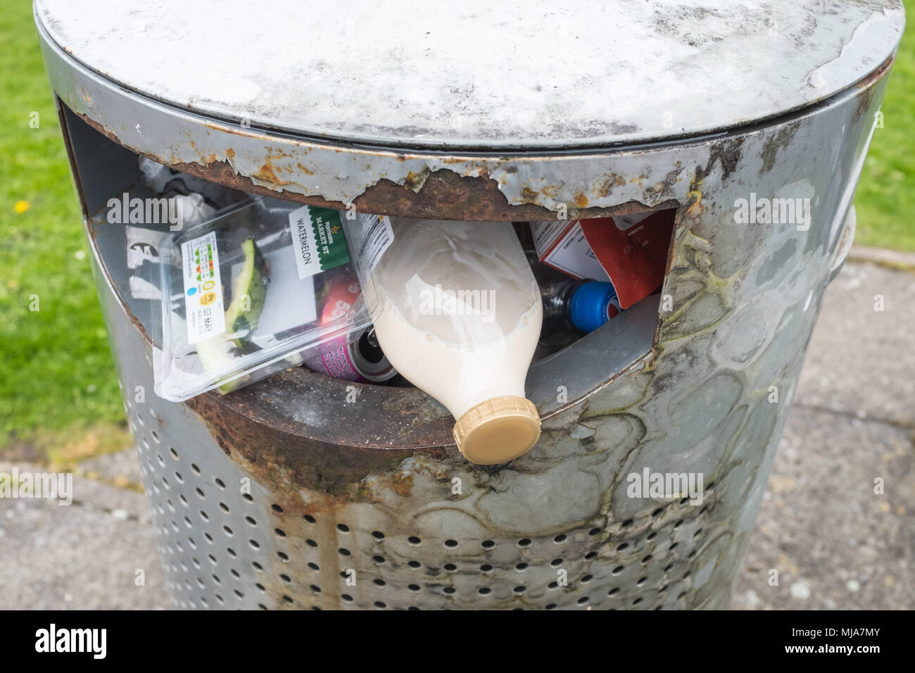 Close up di un cestino della spazzatura che mostra contenitori di plastica alimentare e resti di cibo non consumato. Foto Stock