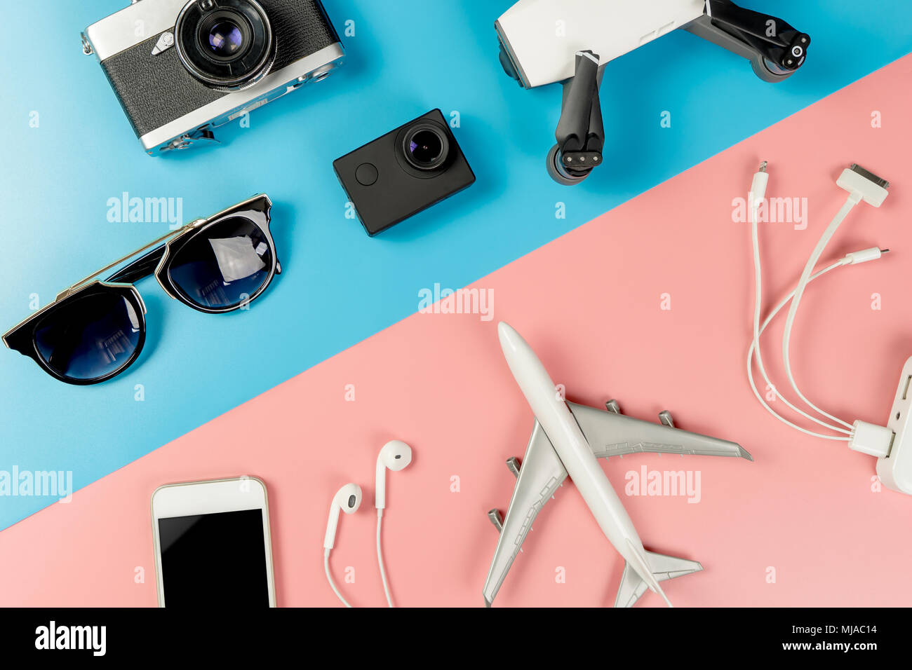 Gadget da viaggio su blu e rosa sfondo pastello Foto stock - Alamy