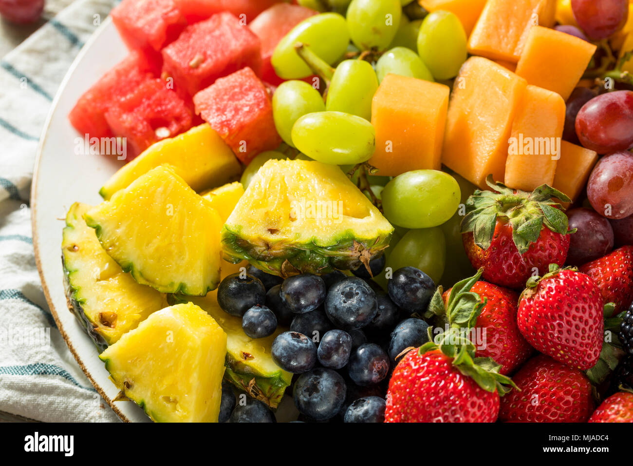 Materie organiche piatto di frutta con bacche di meloni e uva Foto Stock
