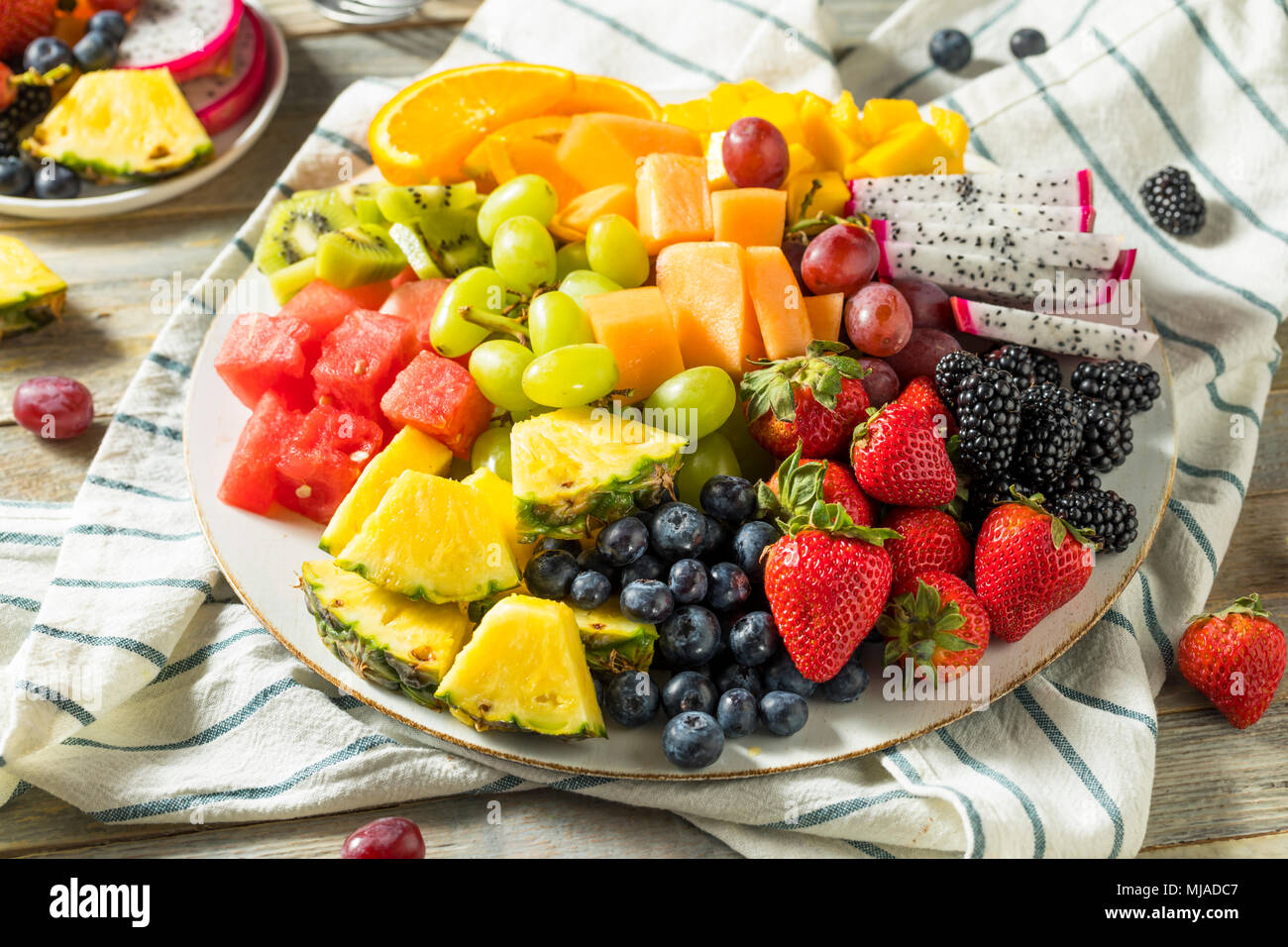 Materie organiche piatto di frutta con bacche di meloni e uva Foto Stock