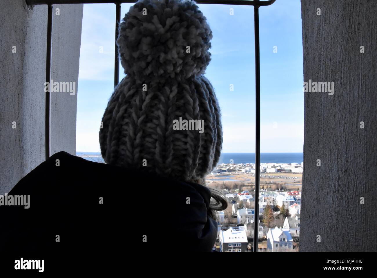 Una donna che guarda attraverso la finestra della chiesa Hallgrimskirkja in Reykjavik Islanda Foto Stock