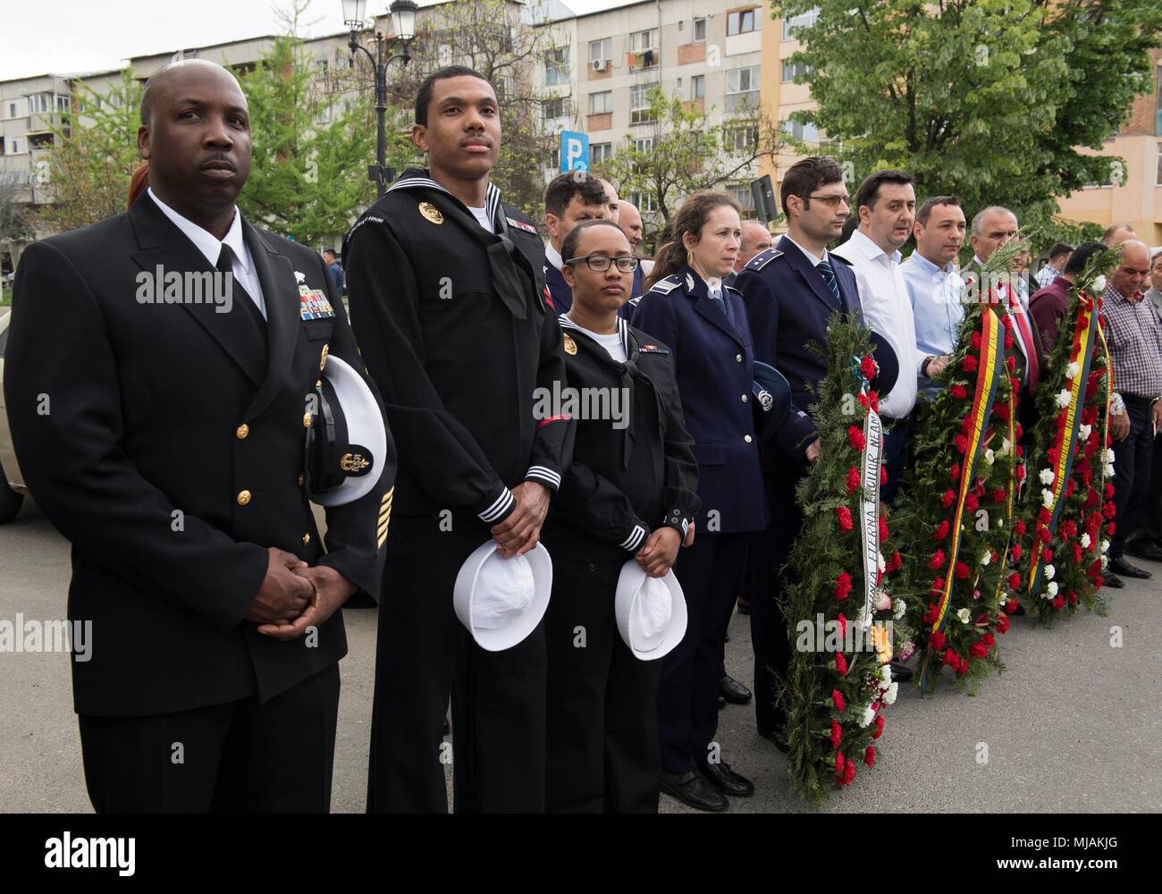 180427-N-BK435-0298 CARACAL, Romania (27 aprile 2018) DEGLI STATI UNITI I marinai della marina e il rumeno i membri del servizio di stare in piedi insieme in onore di coloro che sono caduti durante un veterano rumeno il giorno della cerimonia di premiazione che si terrà a Caracal. NSF Deveselu AAMDS e Romania sono co-localizzato con il rumeno 99th Base Militare e gioca un ruolo chiave nel missile balistico di difesa in Europa orientale. (U.S. Foto di Marina di Massa lo specialista di comunicazione 1a classe Jeremy Starr/rilasciato) Foto Stock