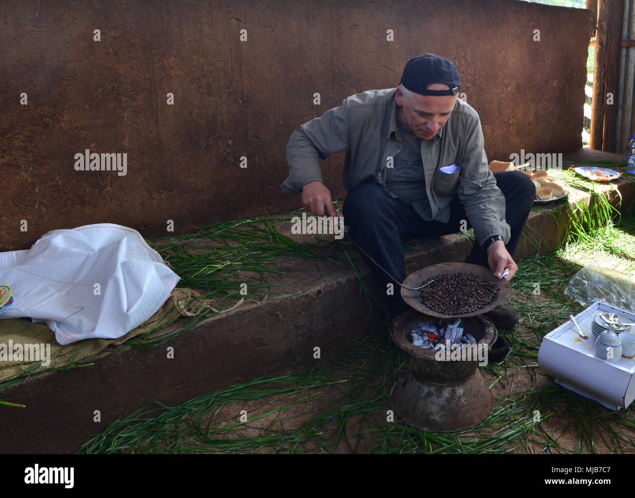 Torrefazione del caffè presso il caminetto, su una tradizionale teglia etiope. Suke Quto Coffee Farm, Guji, Etiopia Foto Stock