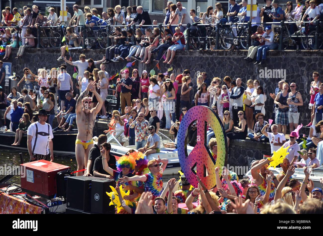Amsterdam, Paesi Bassi: Zoom-in vista di una barca affollata durante l annuale orgoglio canal cruise con il partito popolare, un arcobaleno colorato segno di pace. Foto Stock