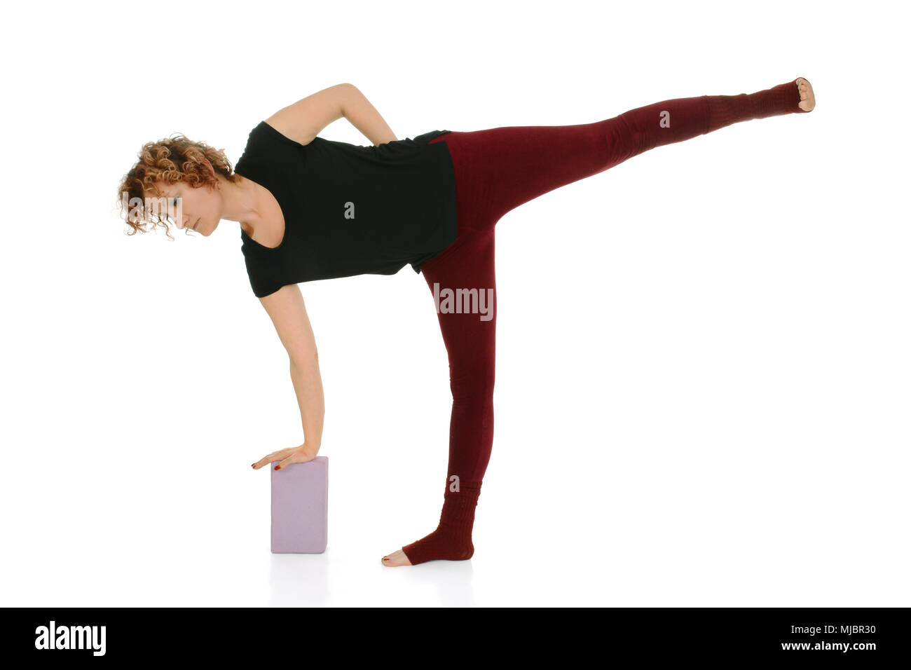 Donna fare yoga della Mezza Luna (Ardha Chandrasana) mediante il blocco,  yoga props Foto stock - Alamy
