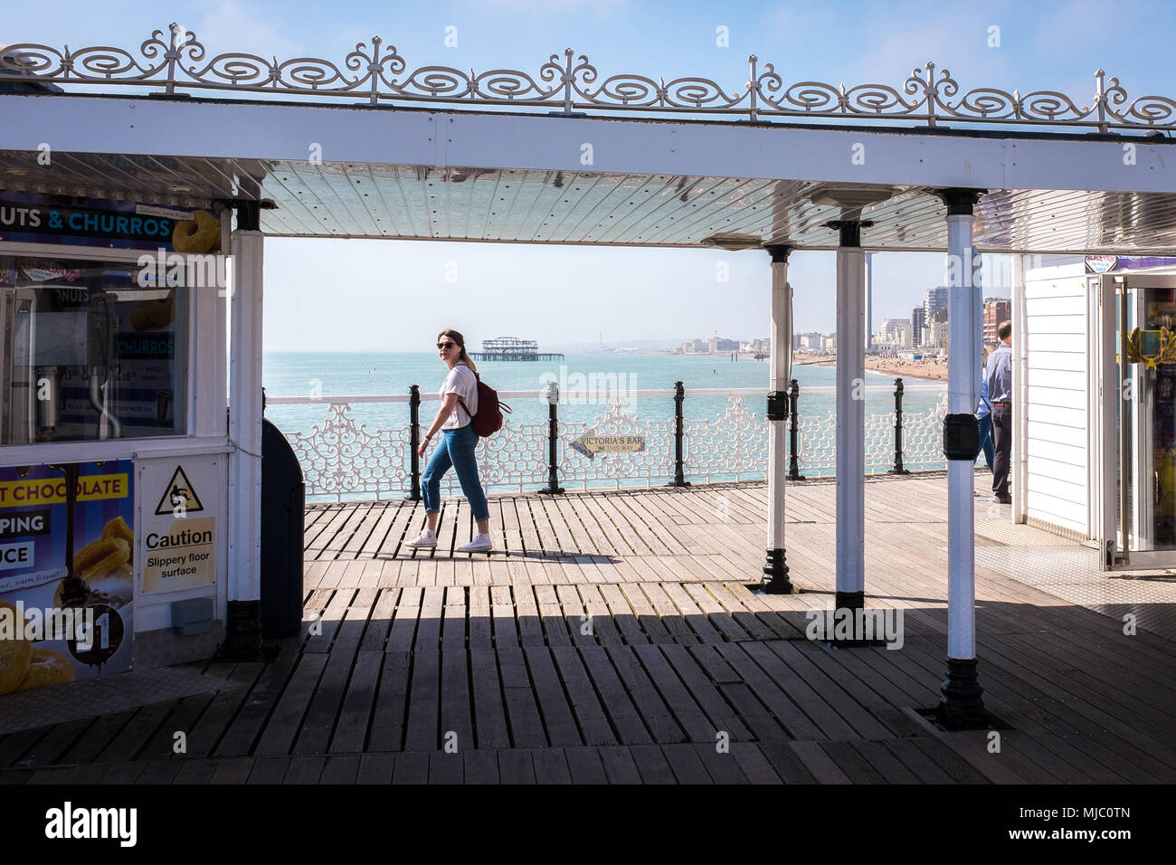 I turisti sul molo di Brighton a fare una passeggiata in una giornata di sole, Brighton, Inghilterra Foto Stock