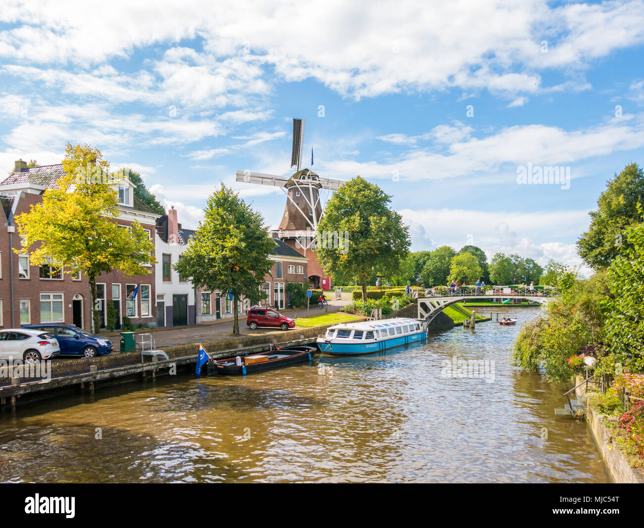 Mulino a vento Zeldenrust e ponte sul canal Kleindiep nella storica città vecchia di Dokkum, Friesland, Paesi Bassi Foto Stock