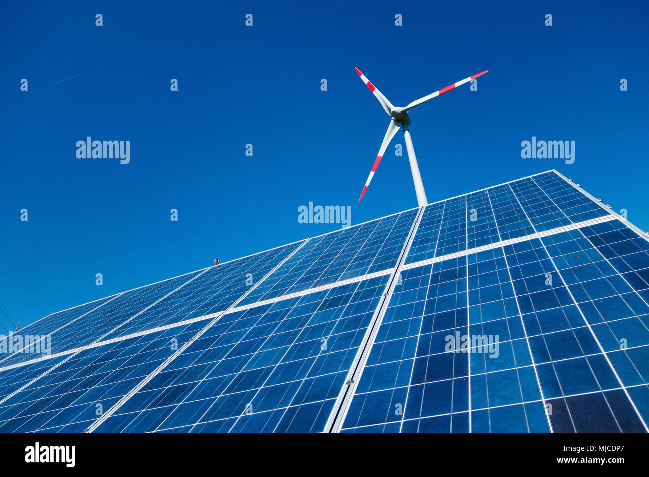 Una combinazione di windpower e solarpower, windmill e solarpanel Foto Stock