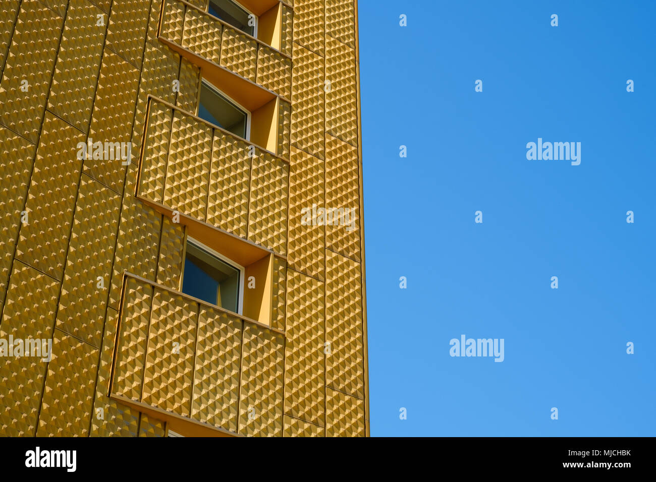 Windows su edificio con facciata d'oro e blu sullo sfondo del cielo Foto Stock
