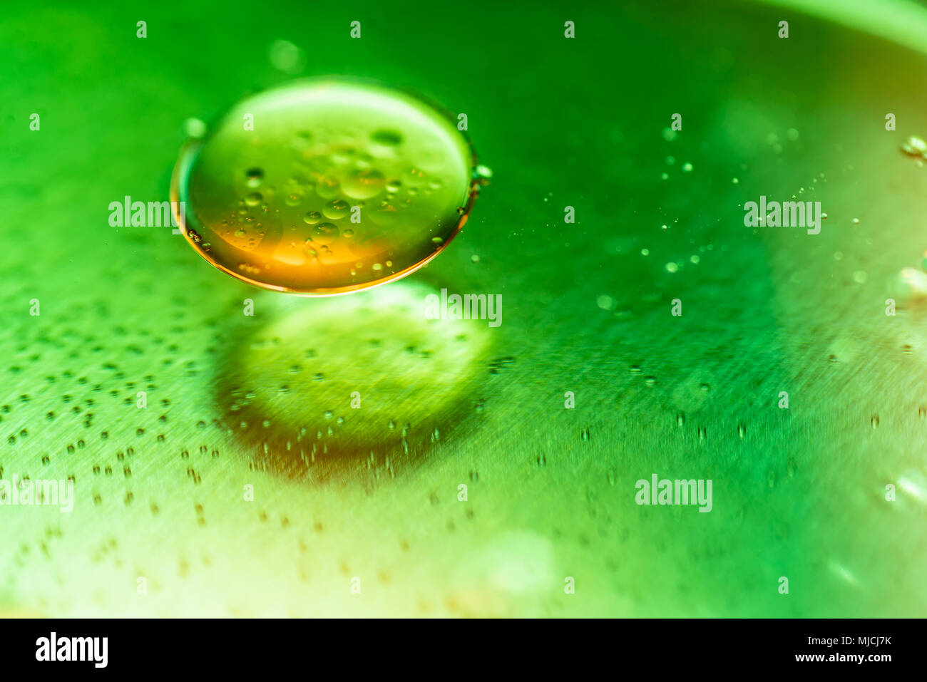 Macro close up di olio bolle appaiono come immagine scientifica della cella e la membrana della cellula in sostanza verde sulla superficie metall. Foto Stock