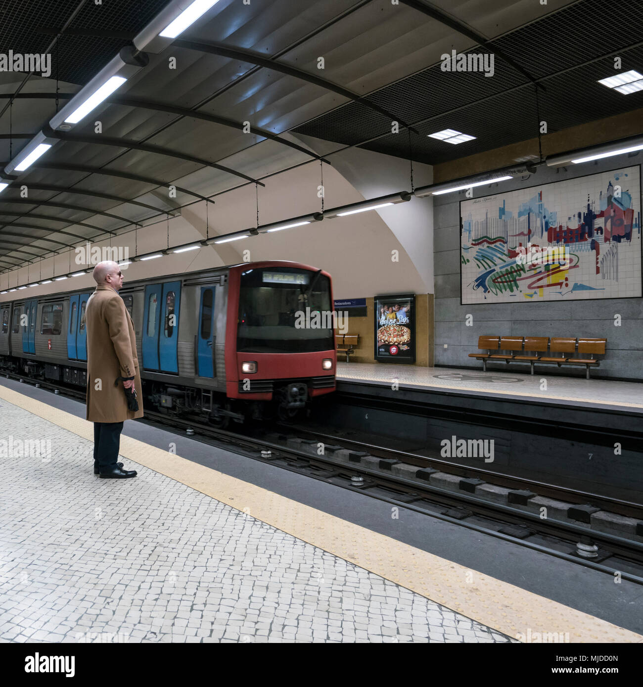 Un uomo in attesa per il treno della metropolitana in una stazione di Lisbona Foto Stock