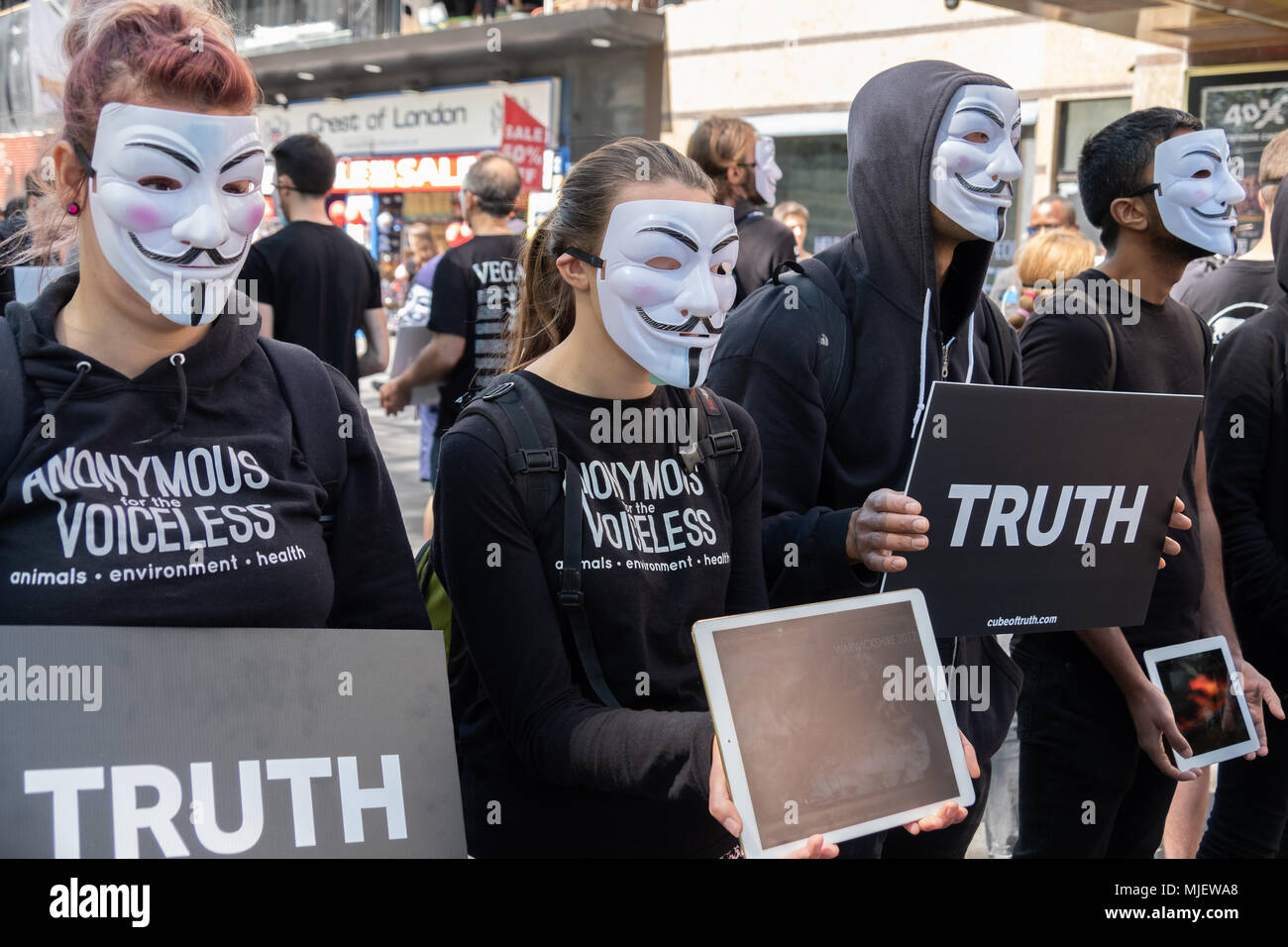 Londra, UK, 5 maggio 2018, manifestanti da anonimo per i senza voce tenere una 12 ore evento statico in Leicester Square per evidenziare la crudeltà verso gli animali nella catena alimentare, mentre il sostegno positivo un stile di vita vegano. I manifestanti hanno tenuto i segni la lettura di verità e ha mostrato il filmato su computer portatili a sostegno della loro causa. Credito: Adrian lobby/Alamy Live News Foto Stock