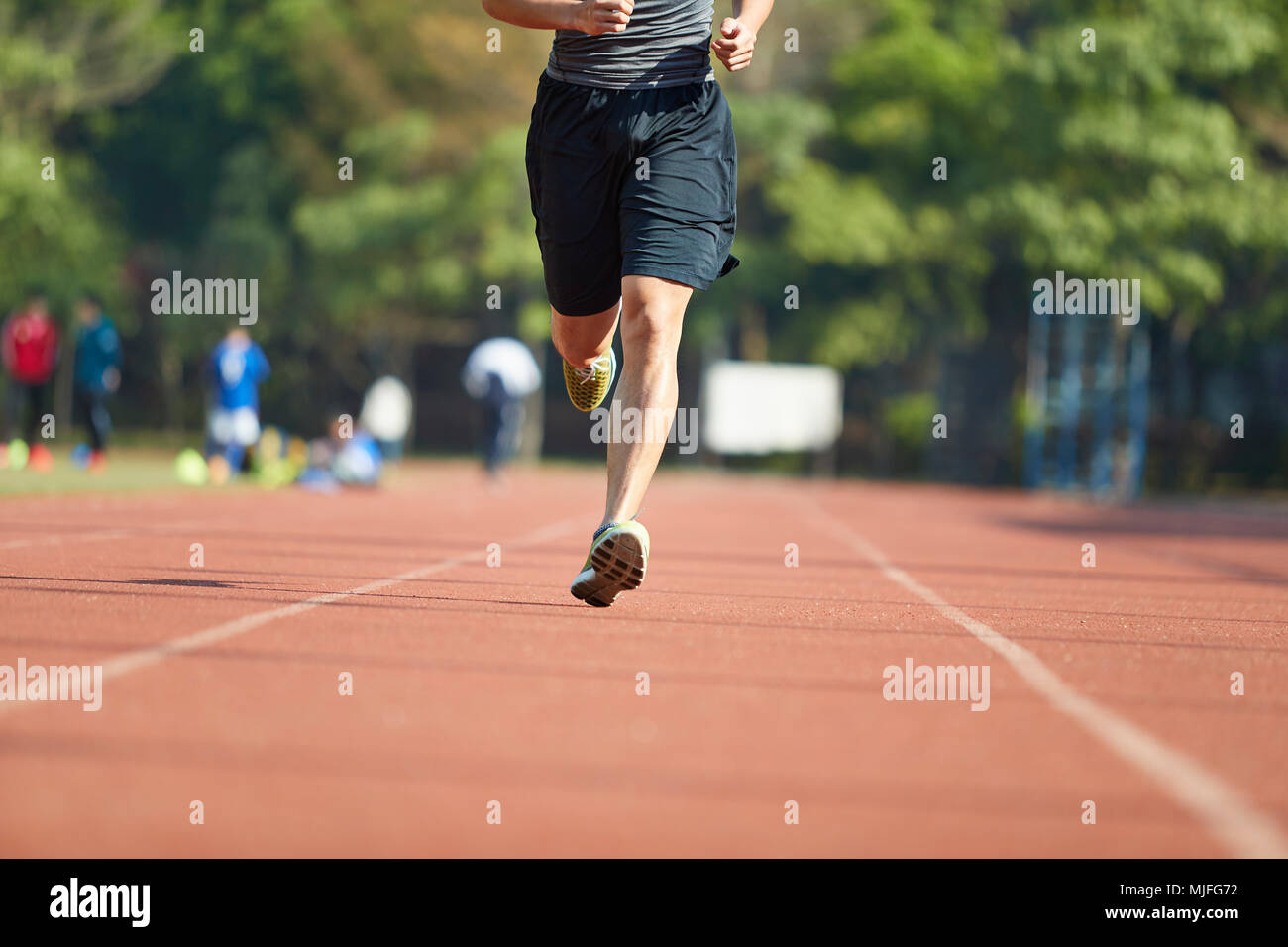 Giovane uomo asiatico atleta maschio esegue la formazione esercita sulla via. Foto Stock