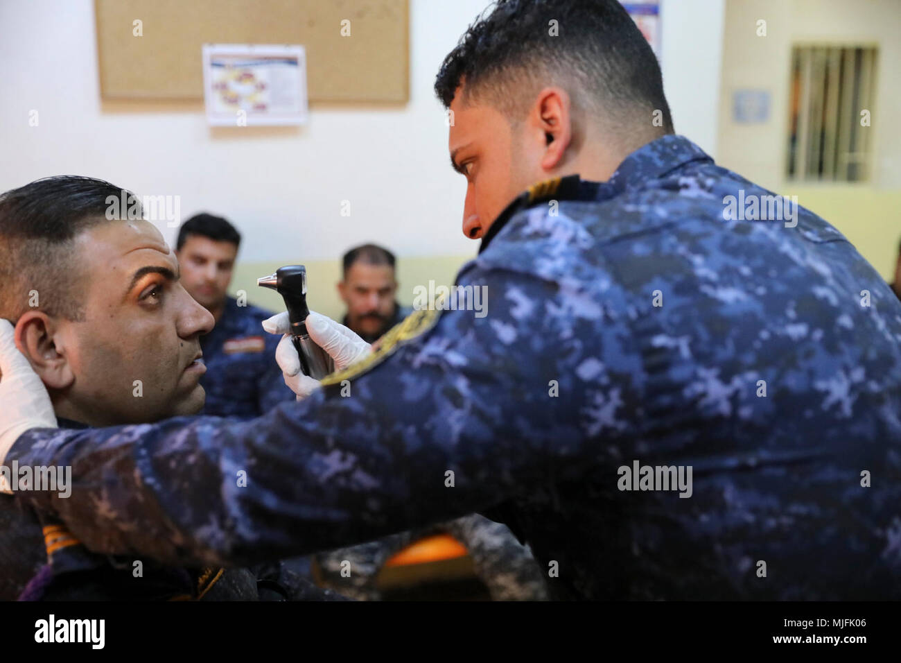 Due iracheni della polizia federale deputati controllare gli alunni seguendo una luce durante una visita medica di corso di formazione di Camp Dublin, Iraq, Marzo 20, 2018. Questo corso di formazione è parte di funzionamento inerenti risolvere la coalizione globale della campagna militare per sconfiggere ISIS in Iraq e la Siria. (U.S. Esercito Foto Stock