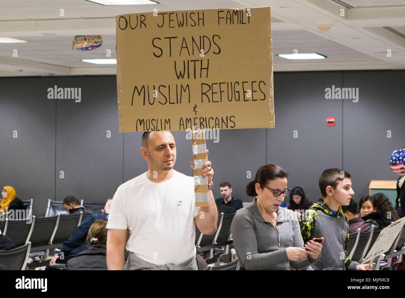 I manifestanti in attesa di segni di protesta durante un rally Presidente contrapposte Trump la proposta di divieto di viaggio volto a maggioranza paesi musulmani detenute al di fuori dell'uscita dalla dogana statunitense presso l'international terminal arrivi dell'Aeroporto Internazionale di Dulles su gennaio 28, 2017 a Dulles, Virginia. Foto Stock