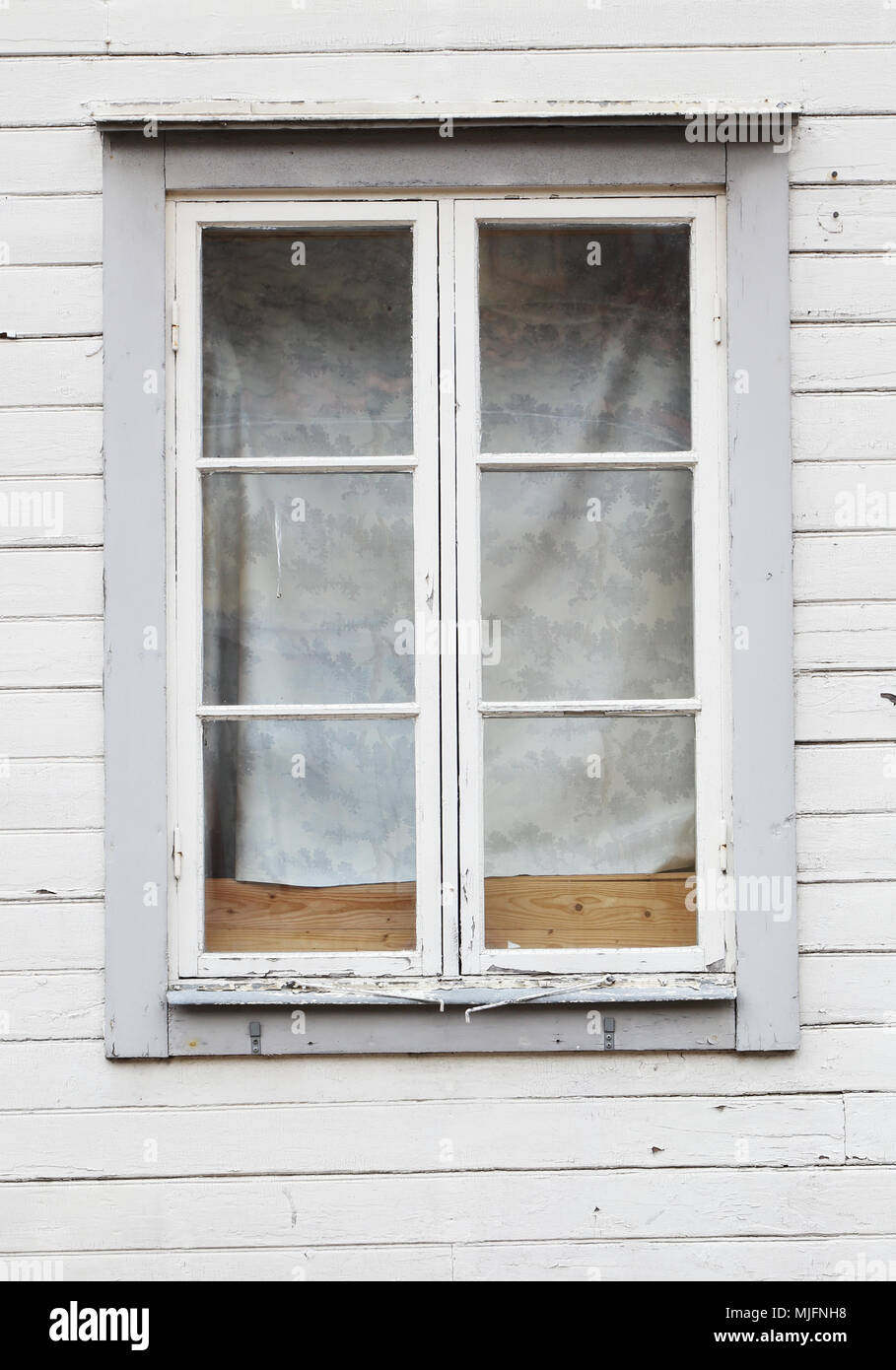 Close-up di finestre chiuse con barre di vetratura in grigio di una svedese di legno vecchio edificio. Foto Stock