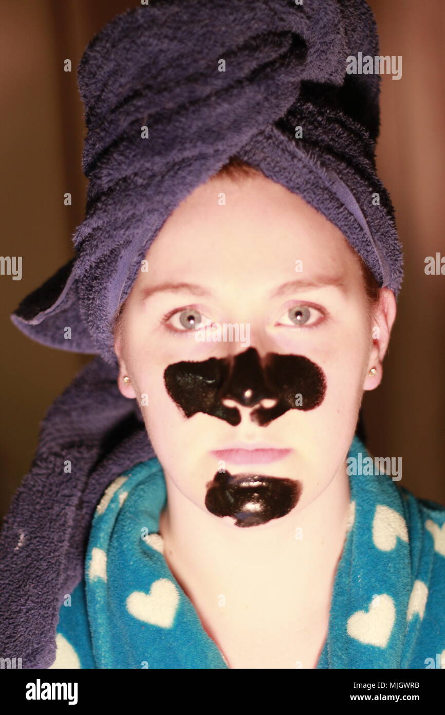 Le donne con una maschera di carbone su come parte del suo regime di bellezza. Questa è una donna caucasica chi è di età compresa tra i 20 e i 25 anni di età ed è britannica di discesa. Foto Stock