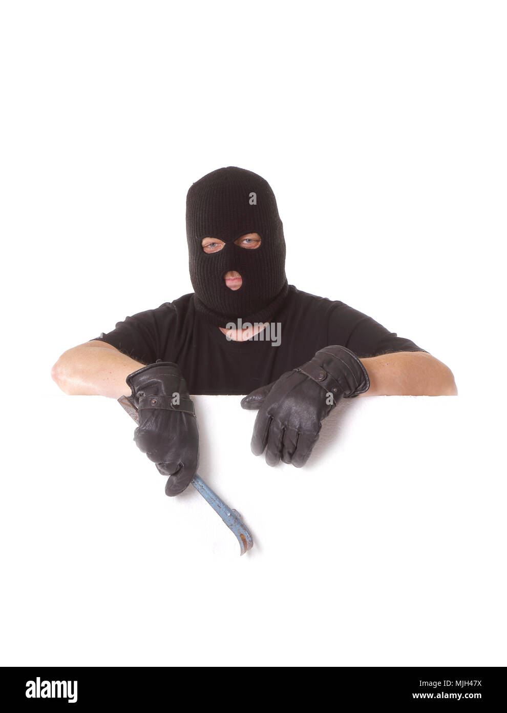 Un uomo mascherato da indossare balaclava tenendo un piede di porco in mano  su uno sfondo bianco Foto stock - Alamy