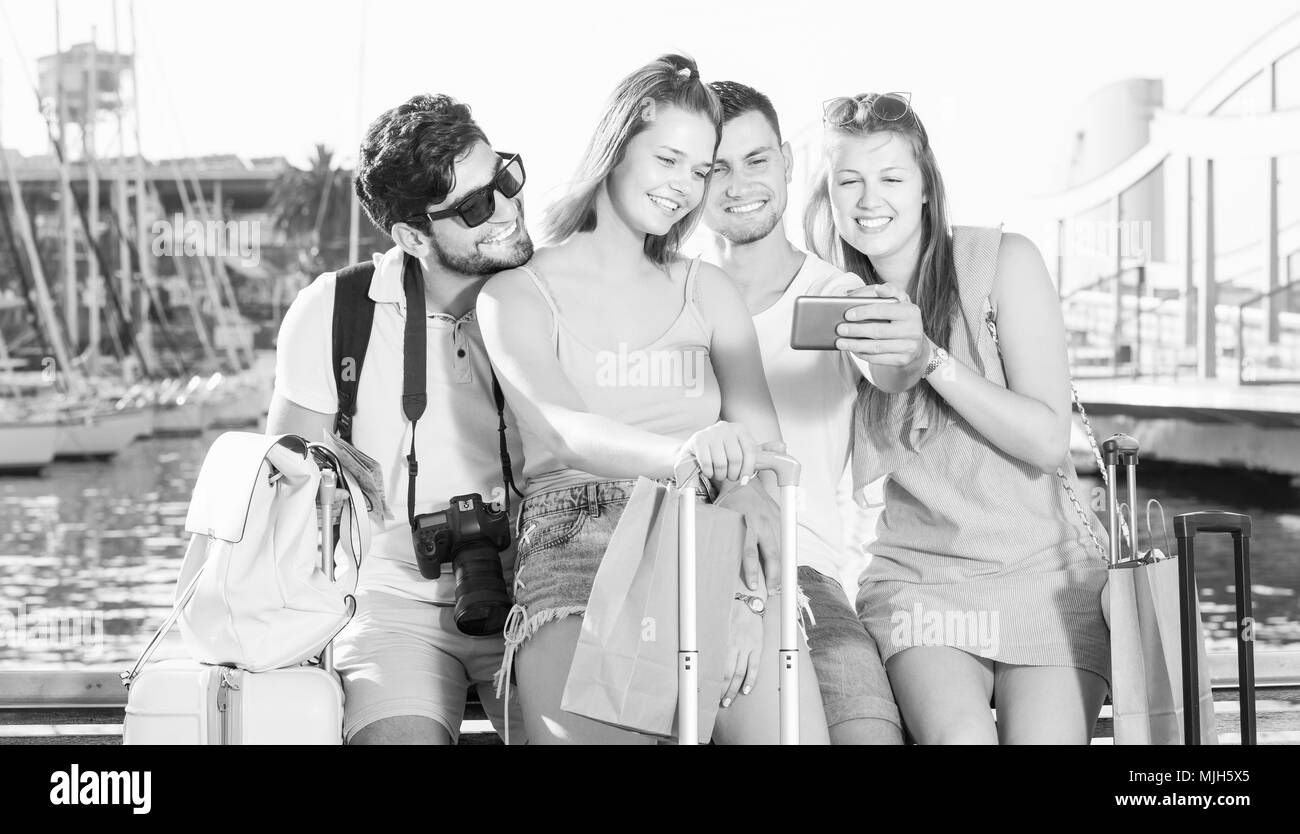 Gruppo di amici viaggiatori sorridente e rendendo selfie con telefono mobile Foto Stock