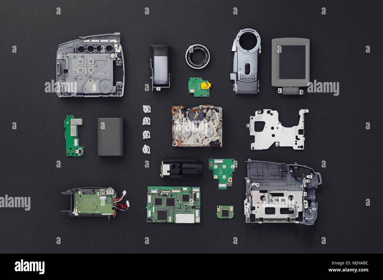 Parti di una mini videocamera DV separati e ben disposti su sfondo nero, vista sopra. Foto Stock