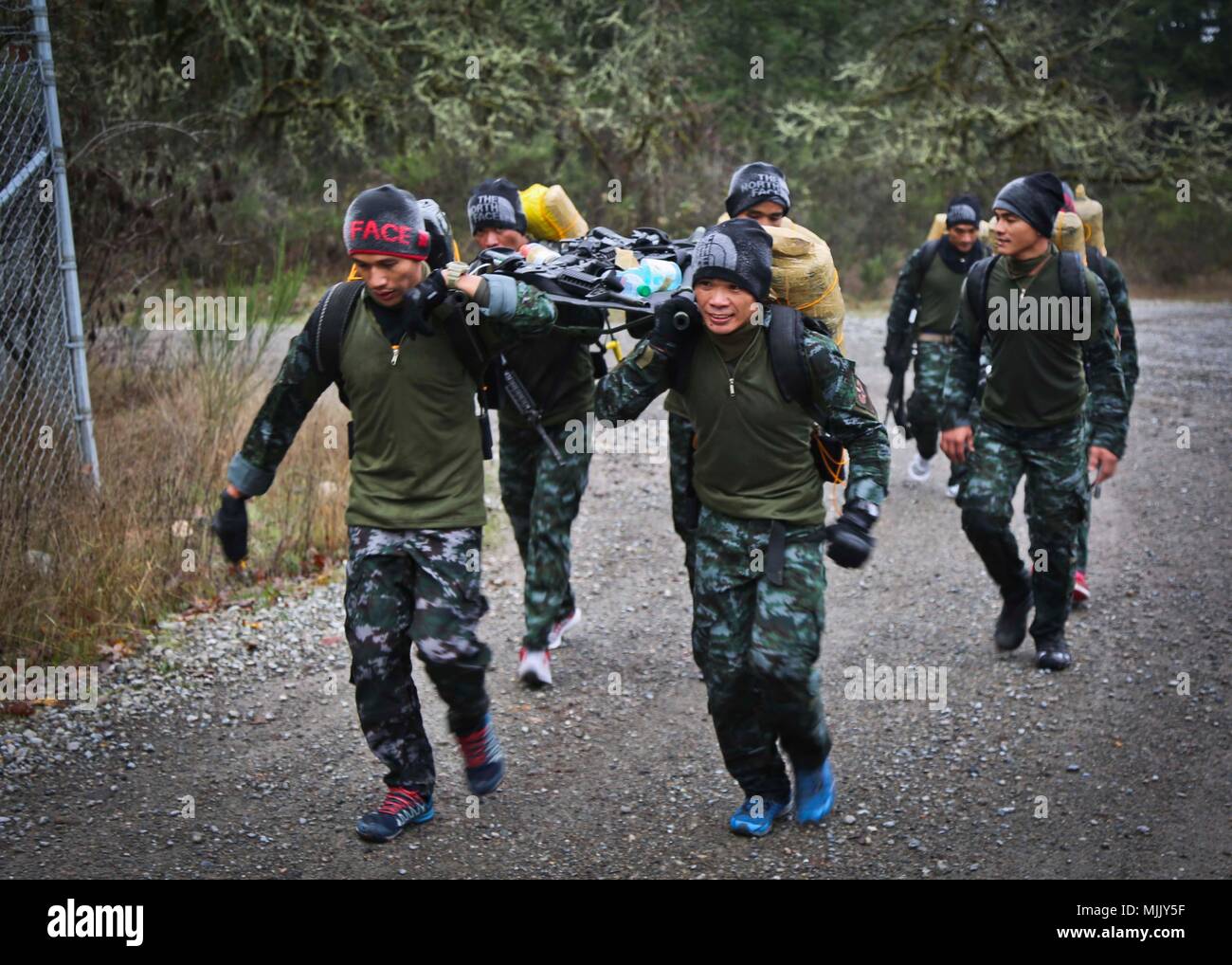 Membri del Philippine National Police partecipare in un ruck temporizzato marzo sfida durante la settimana di Mentone a base comune Lewis-Mccorda, WA, Dicembre 4, 2017. Menton settimana celebra il primo delle forze speciali patrimonio, come il suo predecessore è stato il primo servizio speciale forza, che ha sciolto in Menton, Francia alla fine della II Guerra Mondiale su dicembre 5, 1944. L'unità, comunemente denominato "Vigili del Mali,' è accreditato con un record distinto delle operazioni non convenzionali dietro le linee nemiche. (US Army Foto di SGT Codie Mendenhall). Foto Stock