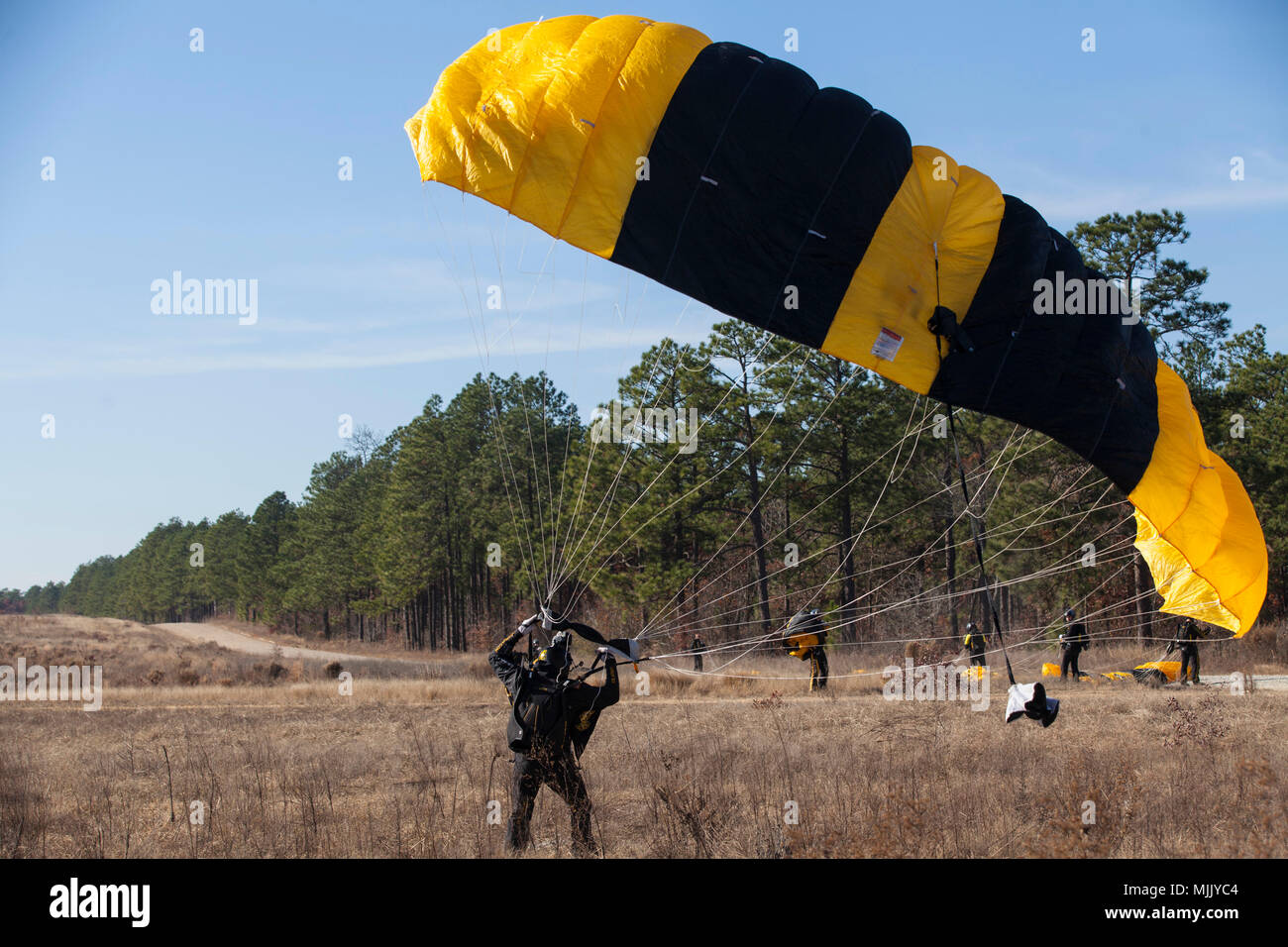 Stati Uniti Paracadutista dell'esercito di Stati Uniti Army Parachute Team (cavalieri d'Oro) terreno durante il ventesimo annuale di Randy Oler Memorial il funzionamento del giocattolo goccia a Camp MacKall, N.C., Dicembre 4, 2017. Quest'anno, otto paesi partecipano ed essi includono; la Colombia, Canada, Lettonia, Paesi Bassi, Svezia, Italia, Germania e Polonia. Il funzionamento del giocattolo Drop, ospitato dall'U.S. Esercito degli affari civili e le operazioni psicologiche il comando (Airborne) è il più grande combinati airborne operazione condotta in tutto il mondo. L'evento consente di soldati la possibilità di allenarsi sul loro militari professionali di specialità, mantenere la loro airborn Foto Stock