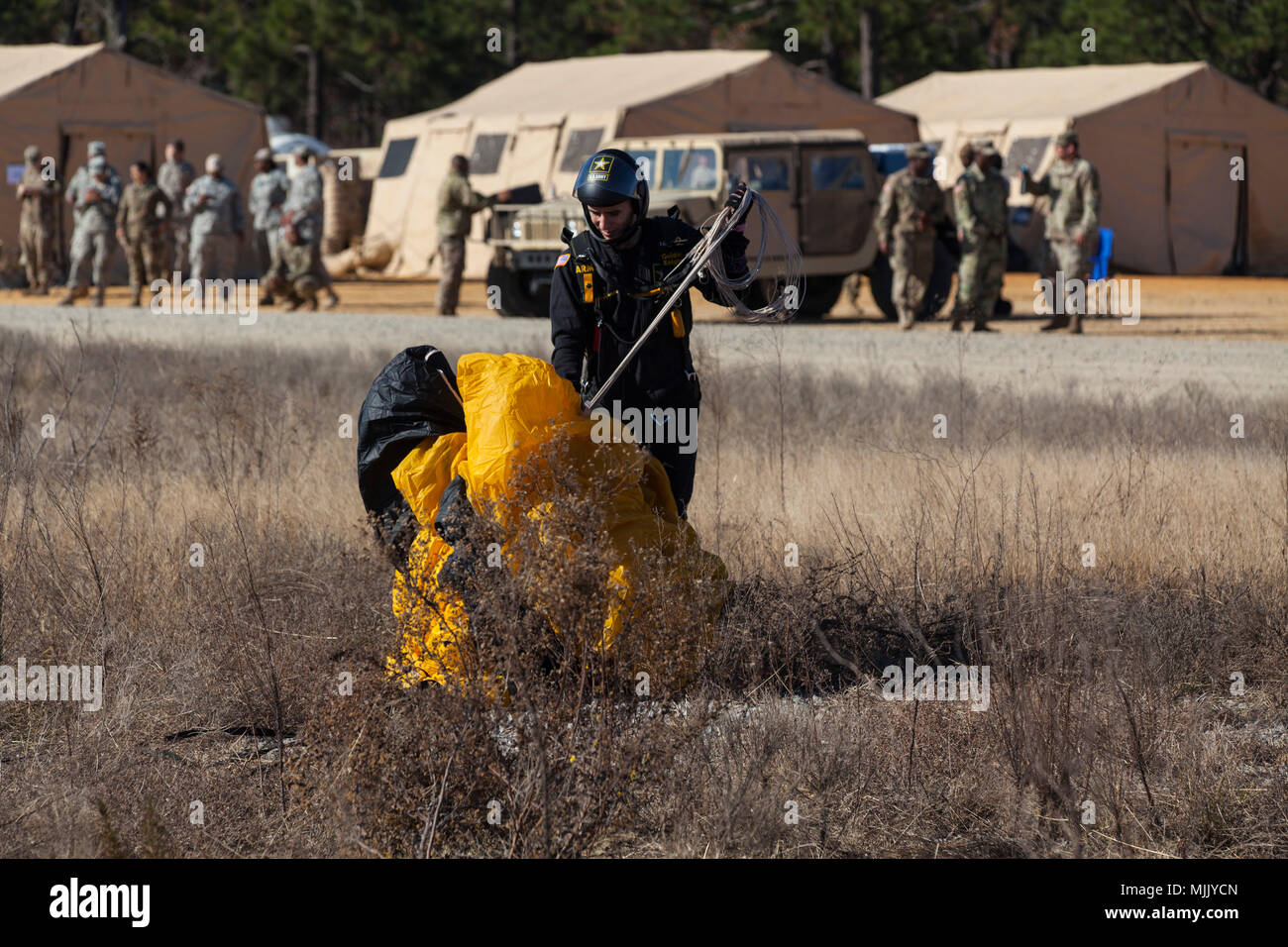 Un U.S. Paracadutista esercito recupera il suo paracadute durante il ventesimo annuale di Randy Oler Memorial il funzionamento del giocattolo di scendere a Luzon nella zona di caduta, Camp MacKall, N.C., Dicembre 4, 2017. Quest'anno, otto paesi partecipano ed essi includono; la Colombia, Canada, Lettonia, Paesi Bassi, Svezia, Italia, Germania e Polonia. Il funzionamento del giocattolo Drop, ospitato dall'U.S. Esercito degli affari civili e le operazioni psicologiche il comando (Airborne) è il più grande combinati airborne operazione condotta in tutto il mondo. L'evento consente di soldati la possibilità di allenarsi sul loro militari professionali di specialità, mantenere la loro disponibilità aerea, Foto Stock