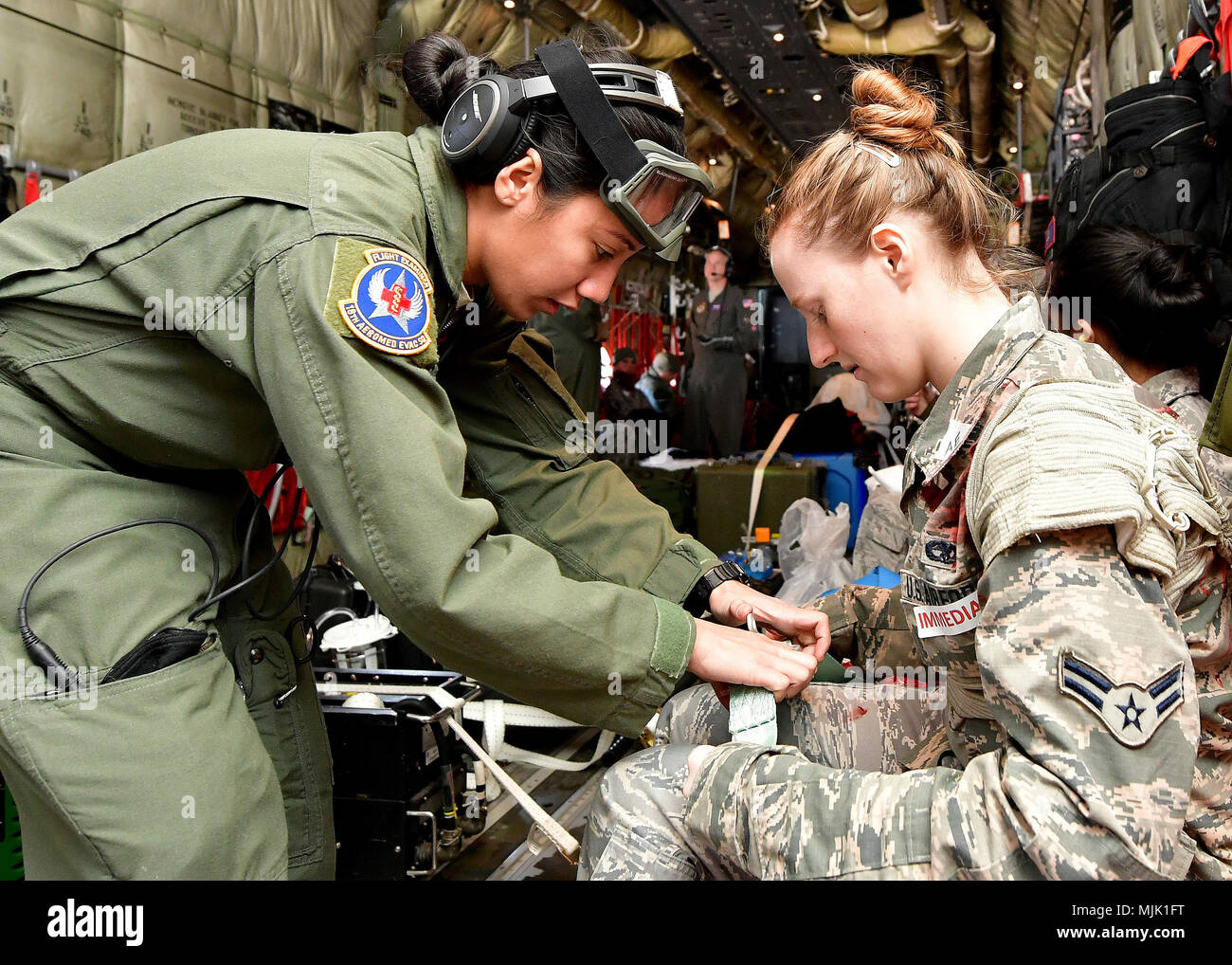 Stati Uniti Air Force Staff Sgt. Andrea miglia, XVIII Medicina Aerospaziale squadrone tecnico, Kadena Air Base, Giappone, assiste un paziente con il fissaggio di una cintura di sicurezza su un U.S. Air Force C-130 Hercules aeromobili cargo stati assegnati ad Yokota AB, Giappone durante l'esercizio vigili Ace 18 a Osan AB, Repubblica di Corea, 6 dicembre 2017. Stati Uniti e RoK forze sono impegnati ad essere pronti a combattere con un preavviso di pochi istanti. Esercitare una rapida risposta scenari mantiene la loro messa a fuoco nitida e pronto a rispondere. (U.S. Air Force photo by Staff Sgt. Franklin R. Ramos/rilasciato) Foto Stock