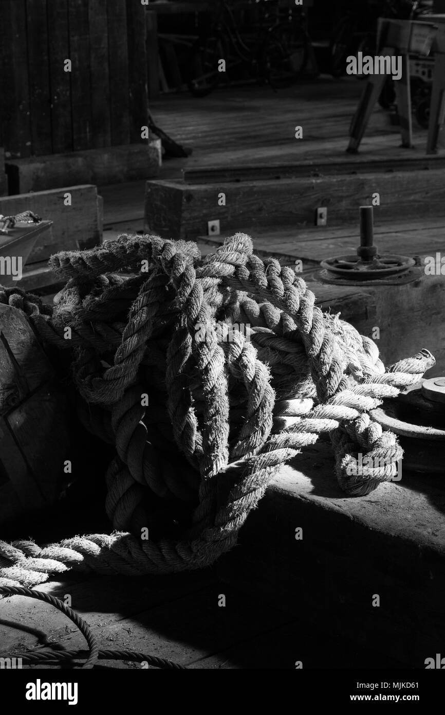 Immagine in bianco e nero di un soleggiato bobina del vecchio di corda in un cantiere navale Foto Stock