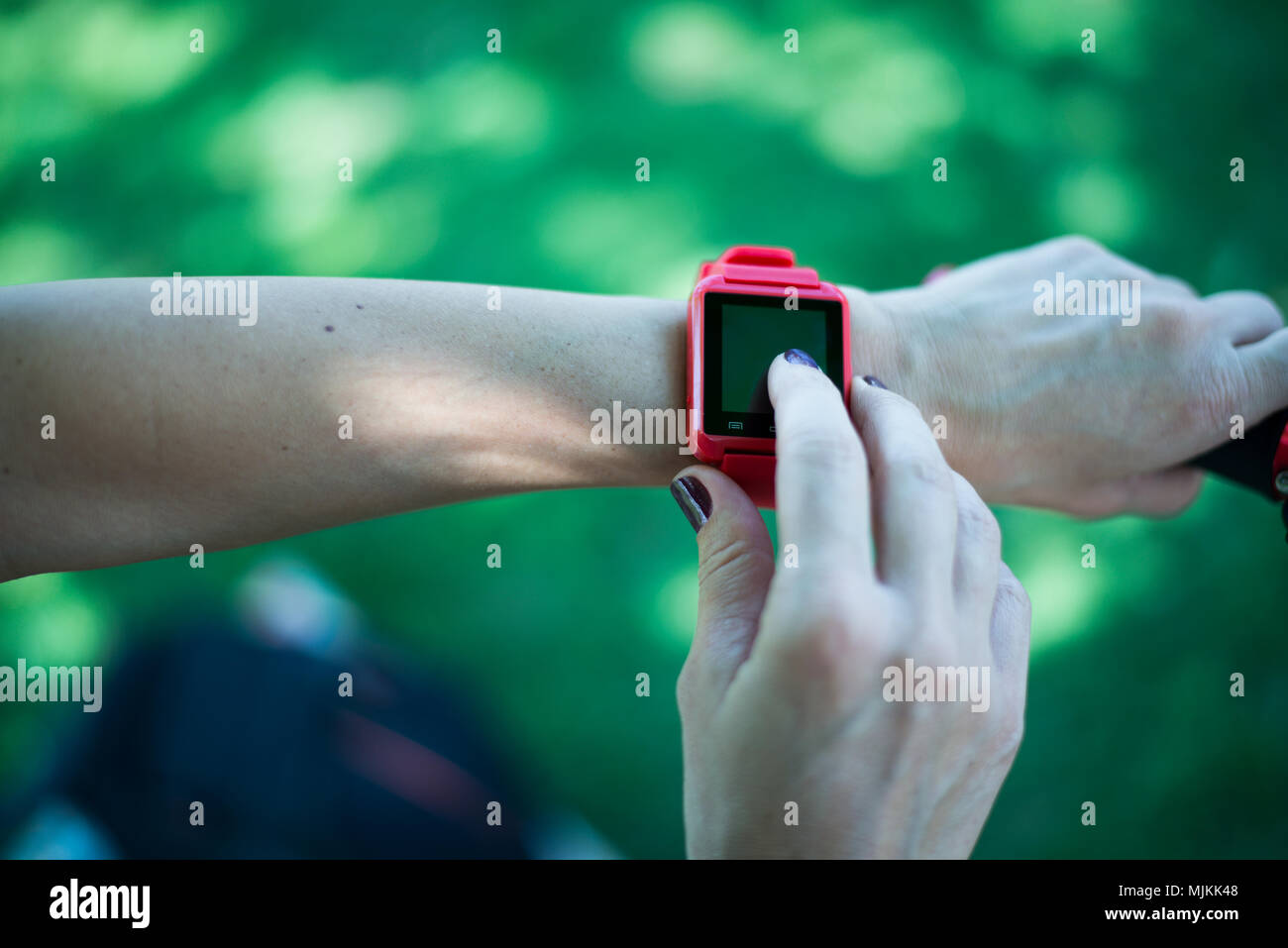 Bucarest, Romania - 26 Ottobre 2017: Persona utilizzando smart watch e uno smartphone a piedi per il parco in una domenica. Donna compiendo gesti su un wearable Foto Stock