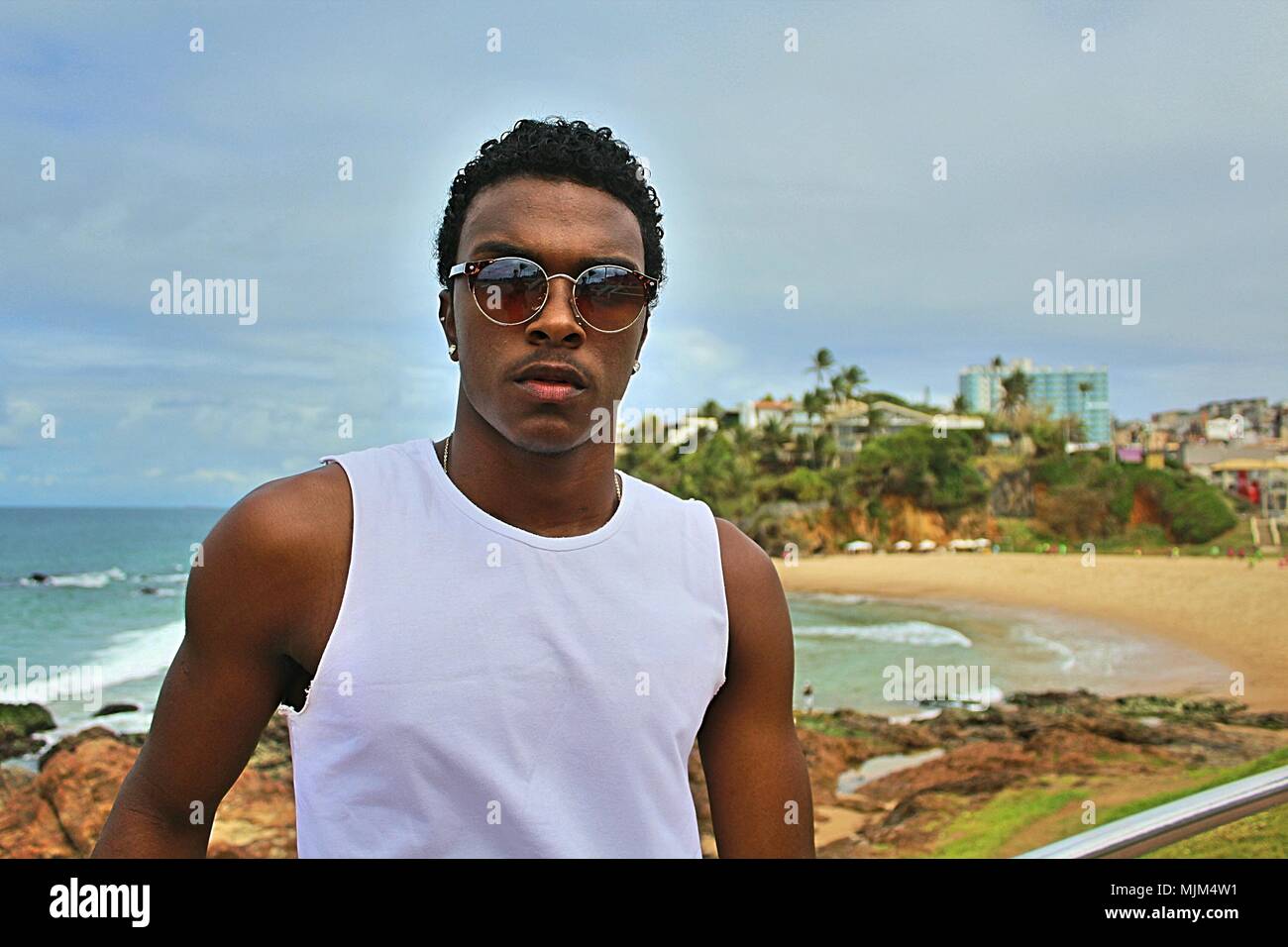 Ragazzo nero con una camicia bianca con un background sulla spiaggia Foto Stock